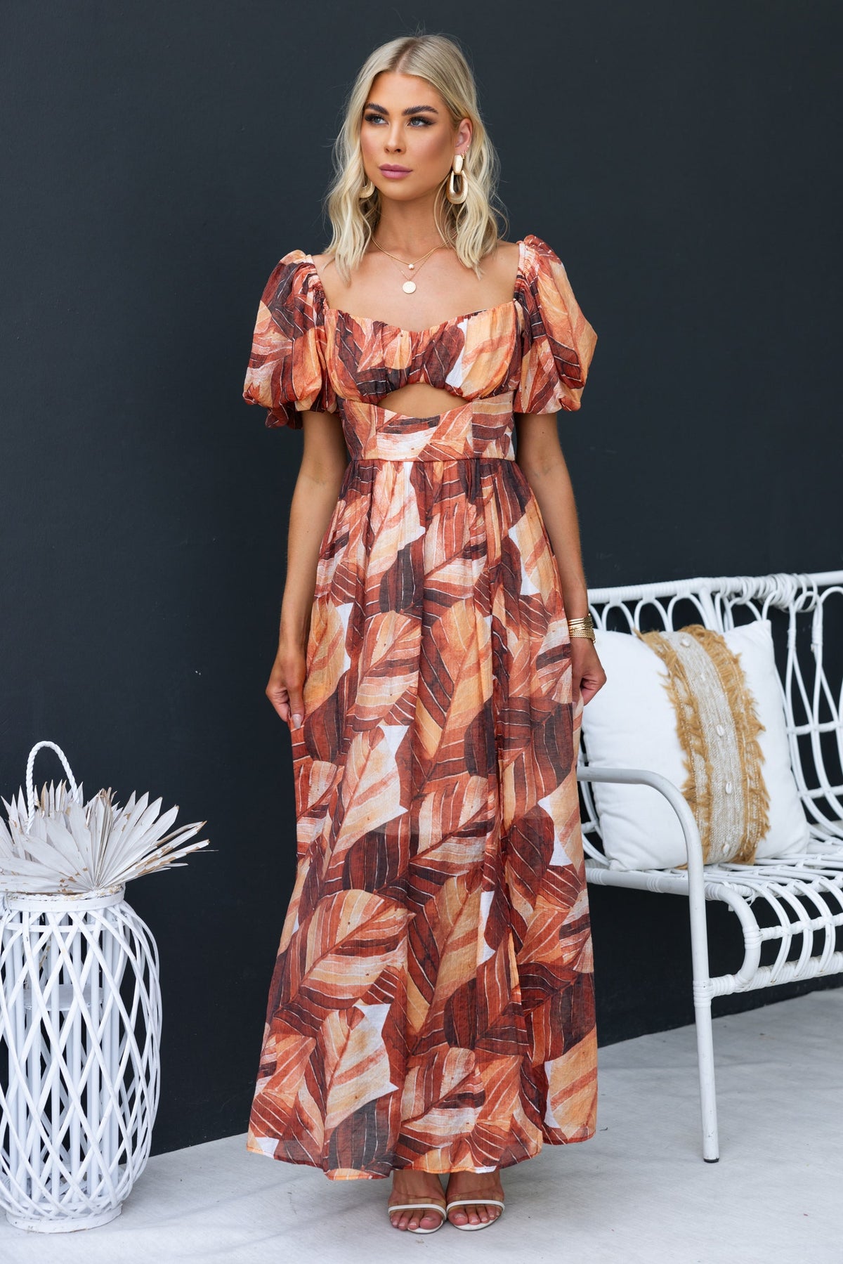 Damaris Maxi Dress with puff sleeves, cut-out under bust, and vibrant leaf print in warm colors.