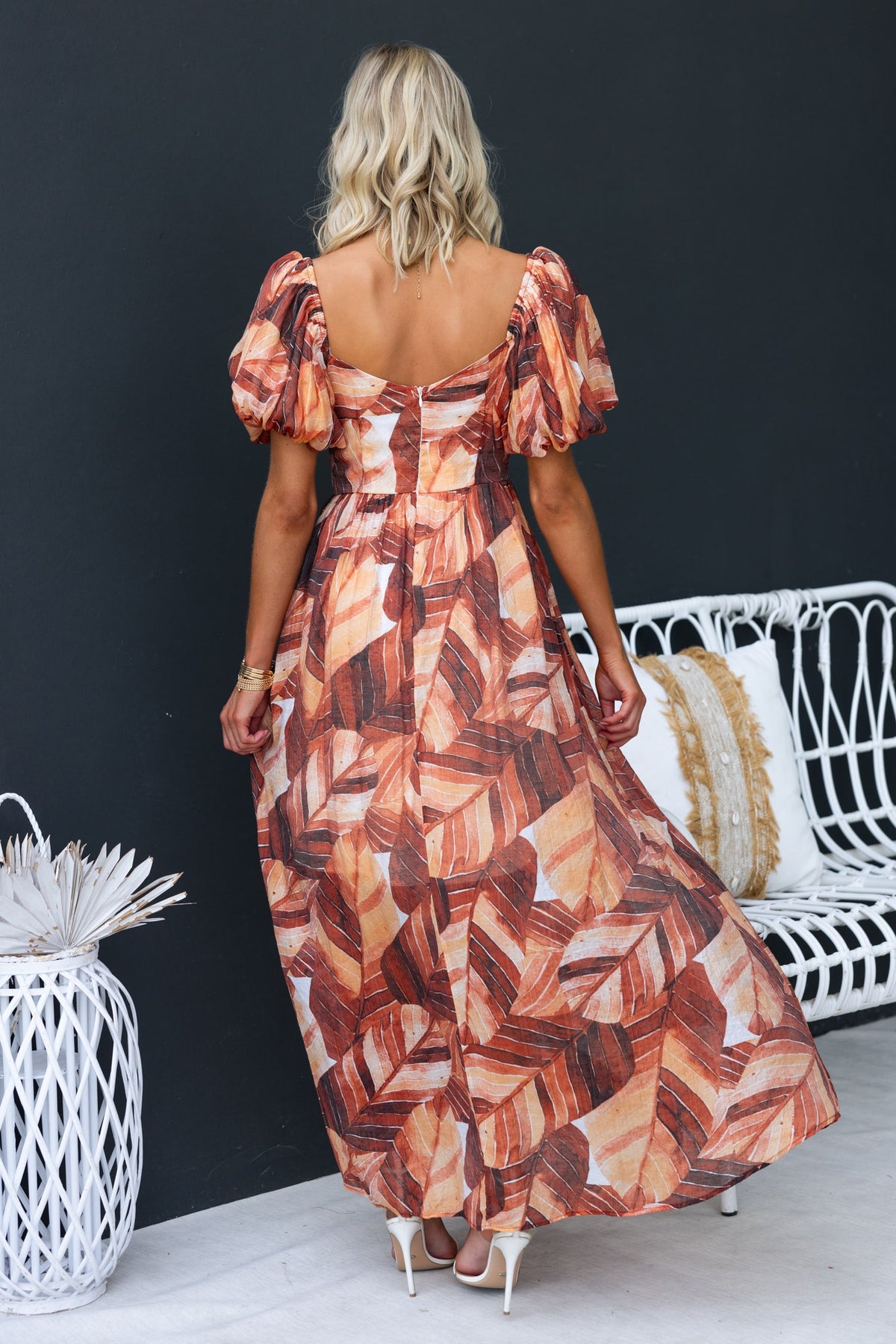 Back view of Damaris Maxi Dress in a colorful leaf print, featuring puff sleeves and a flowing silhouette.