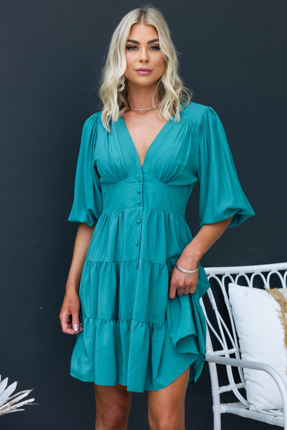Damika Dress in teal with V-neckline and button-up front, featuring puff sleeves and tiered design.