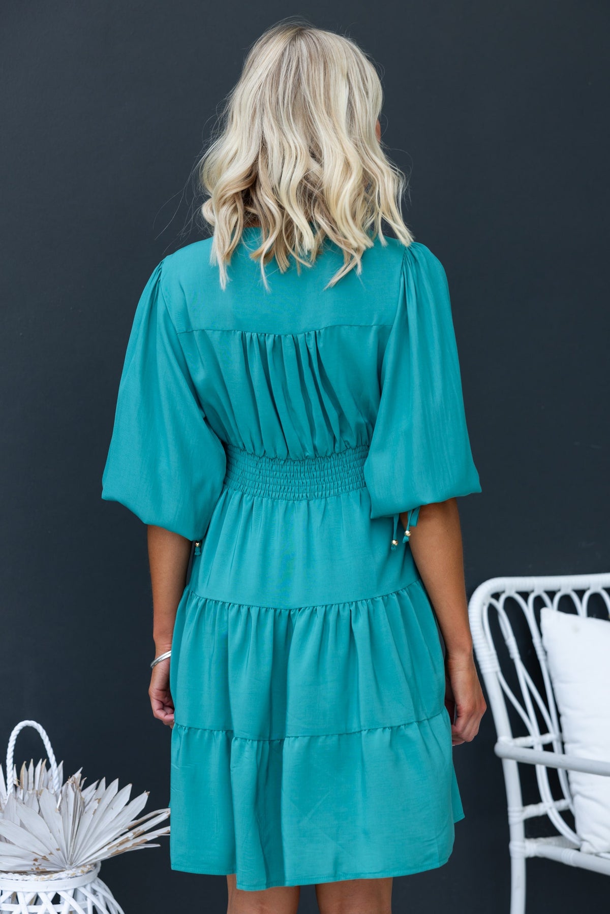 Back view of Damika Dress in teal, showcasing elastic back and drawstring sleeves, perfect for casual summer wear.