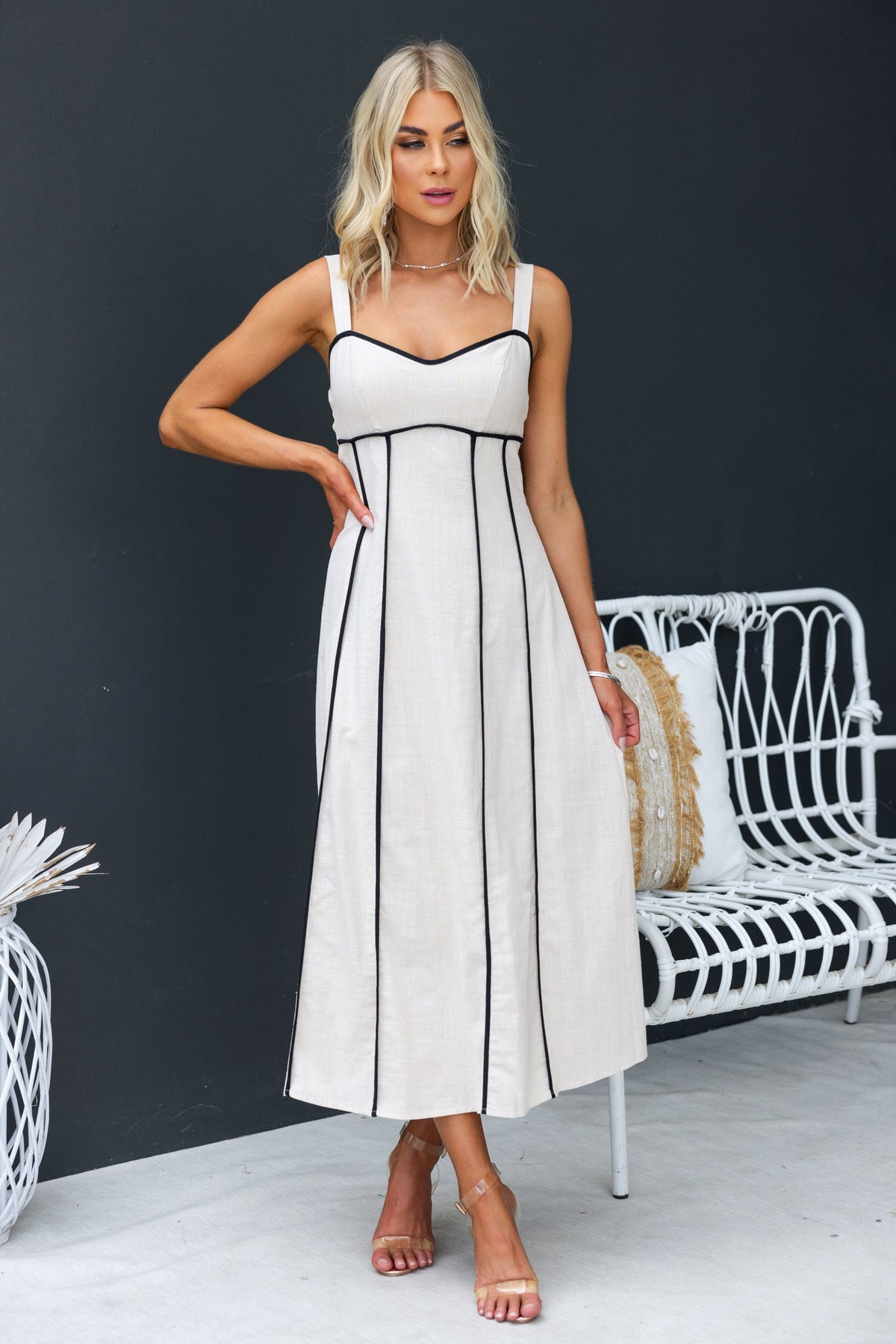 Temila Midi Dress with adjustable straps, featuring a linen look and lined design, modeled by a woman in a modern setting.