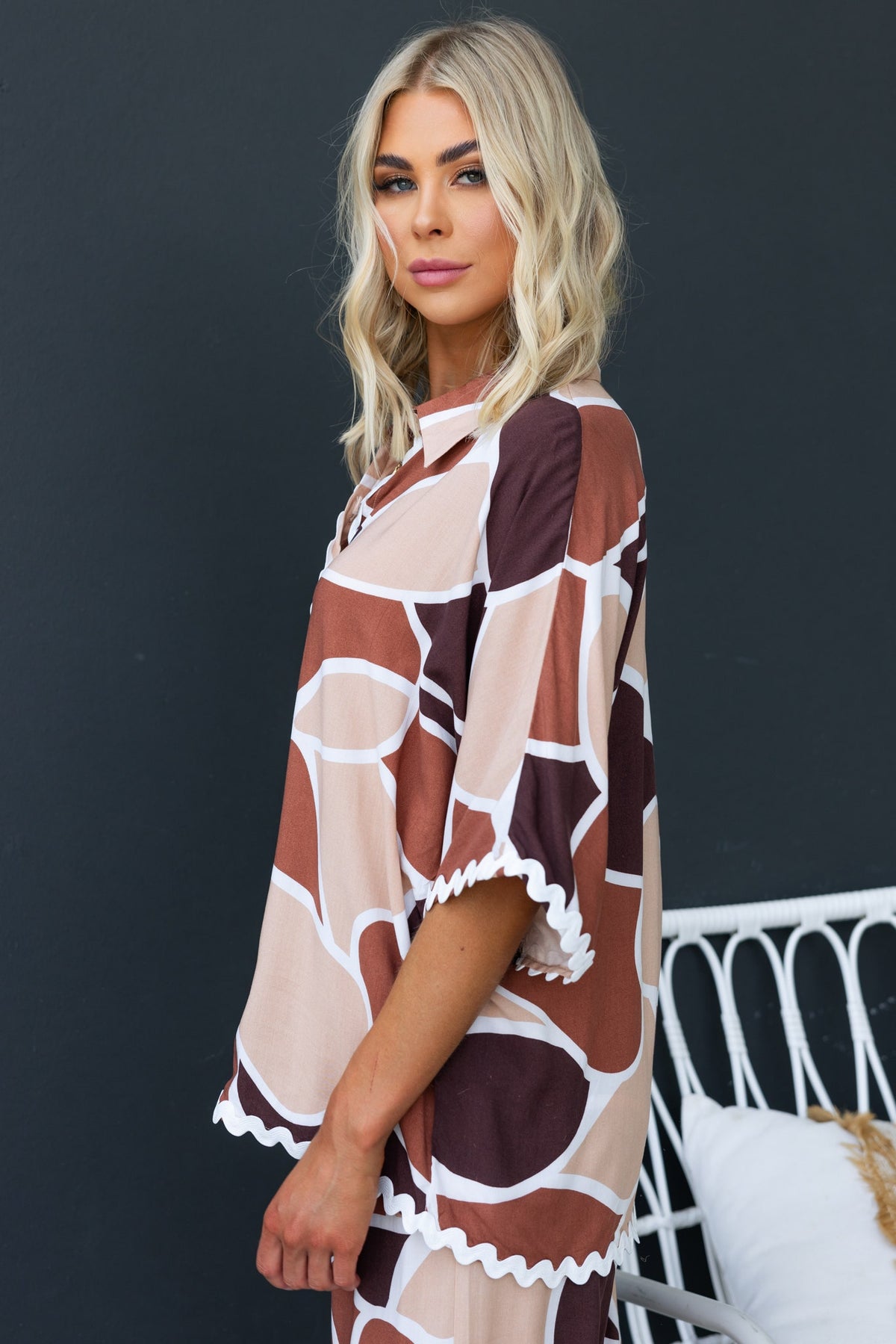 Model wearing Maito Shirt, a casual, relaxed fit rayon shirt with a stylish abstract pattern and scalloped hem.