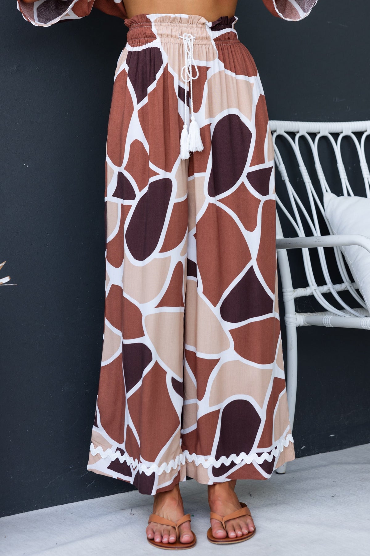 Maito Pants featuring mid-high waist, elastic waistband with drawstring, and stylish abstract pattern in earthy tones.