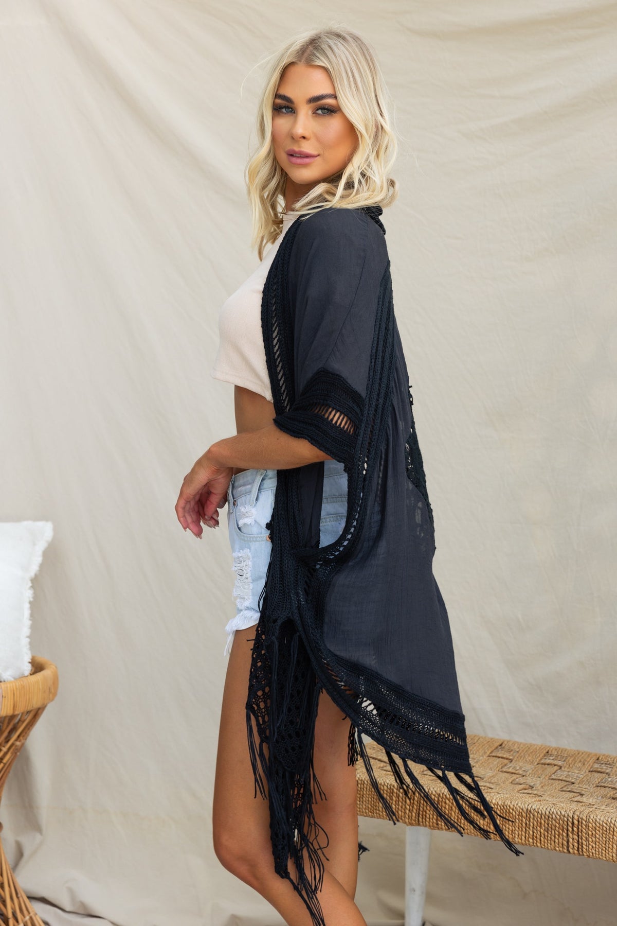 Stylish model wearing a black throwover with bat-wing sleeves and crochet detailing, perfect for a relaxed fit.