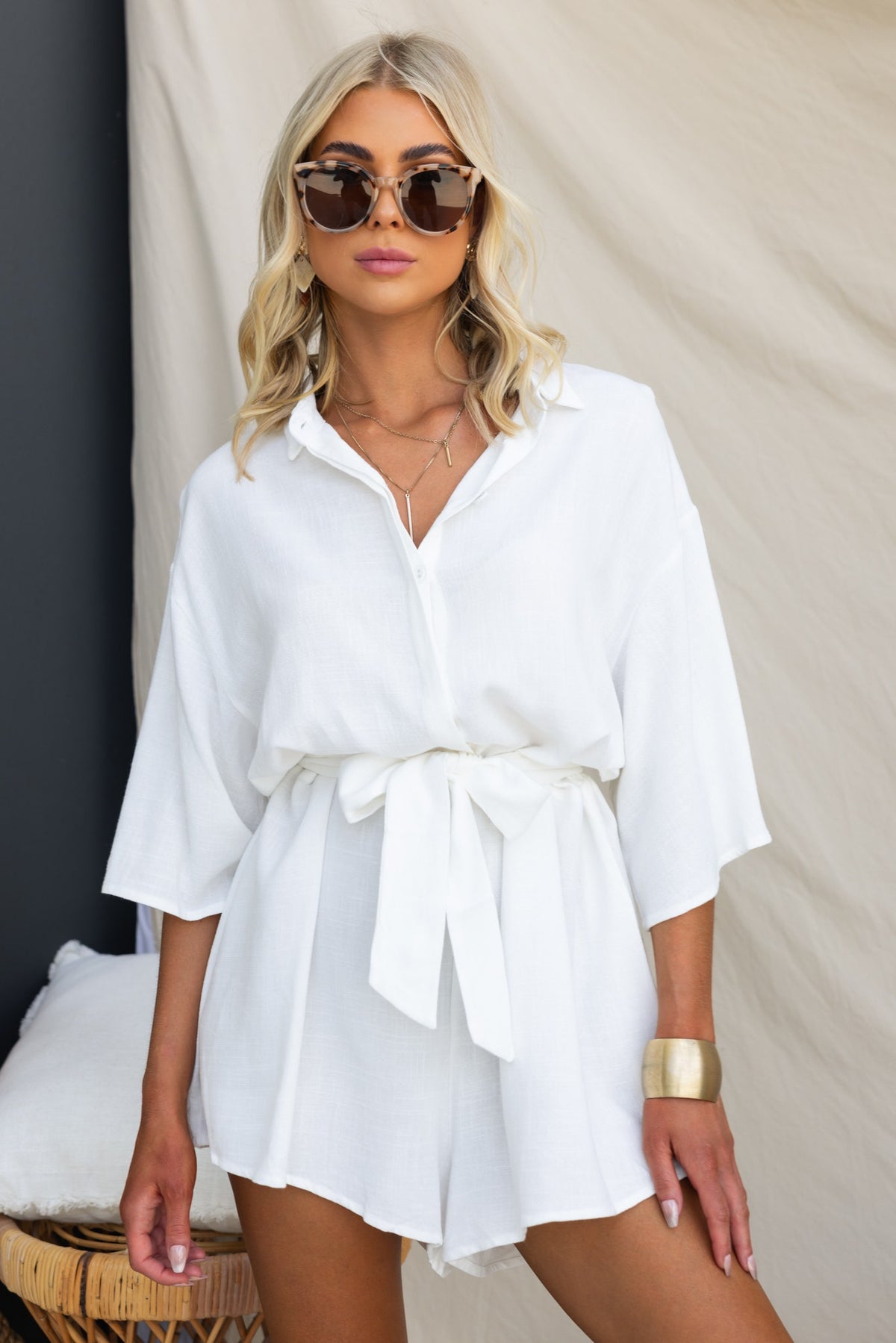 Model wearing the Wyoma Playsuit, a white button-up playsuit with a removable tie, exuding a relaxed summer vibe.