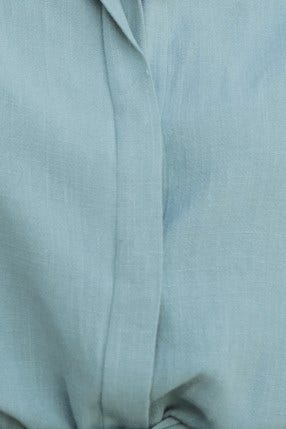Close-up of the soft linen fabric in a pale blue hue of the Wyoma Playsuit, showcasing its texture and smooth finish.
