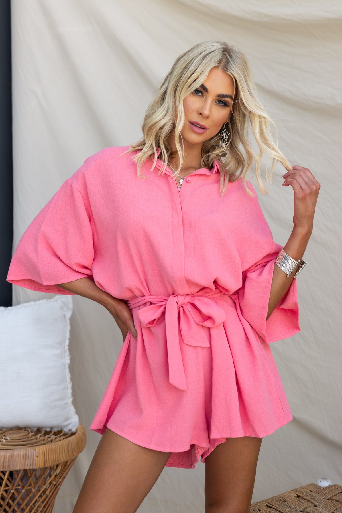 Model wearing a pink Wyoma Playsuit with a collar and belt, showcasing a relaxed fit and linen-like texture.