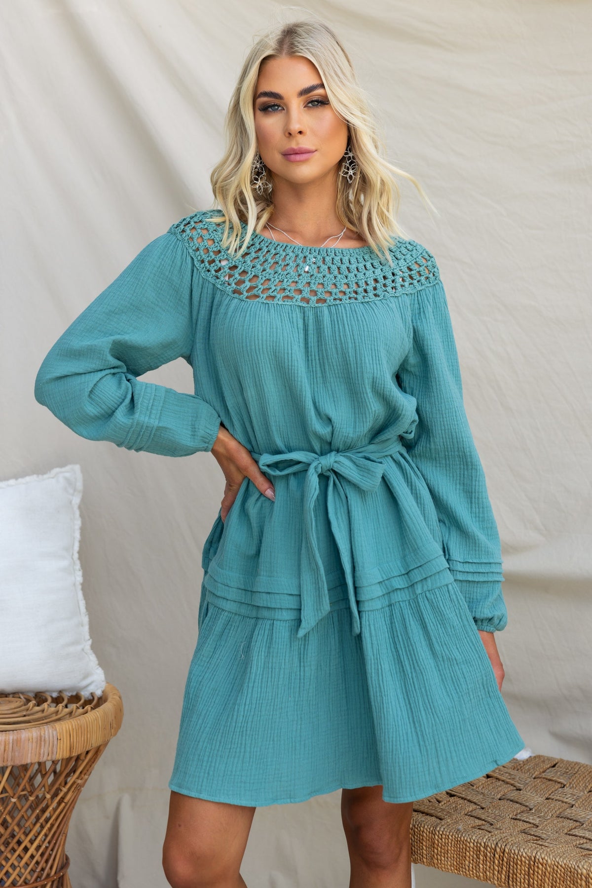 Model wearing the Hejda Dress in aqua with crochet neckline and removable tie belt.