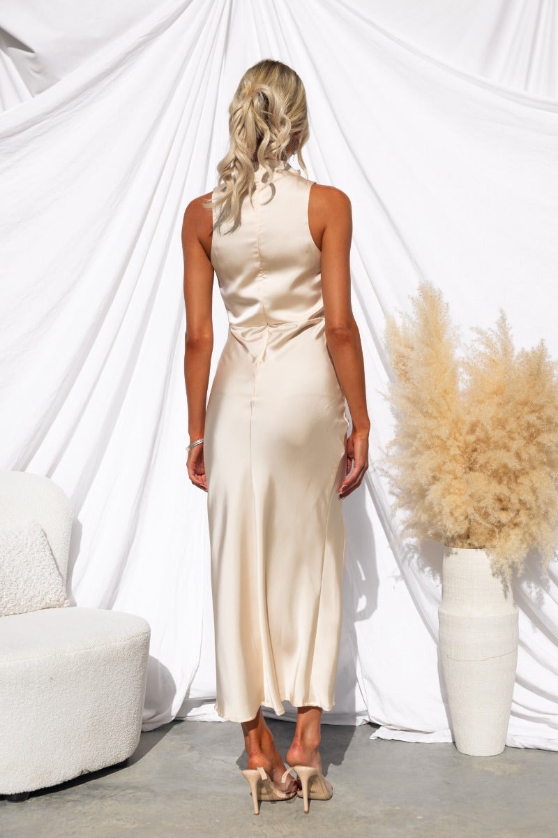 Back view of a satin Honeymoon Maxi Dress with a high neckline and asymmetric hemline against a white backdrop.