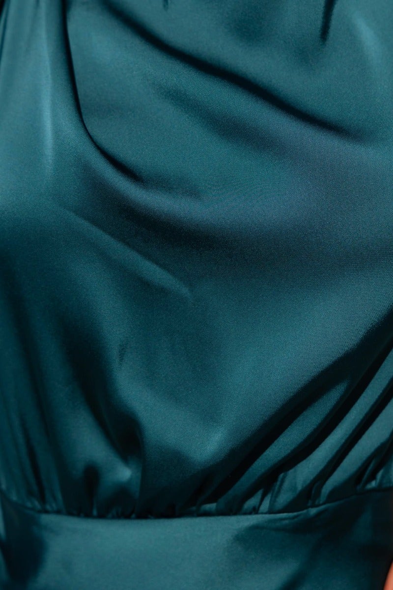 Close-up of a teal satin fabric showcasing its smooth texture and glossy finish, ideal for a stylish maxi dress.