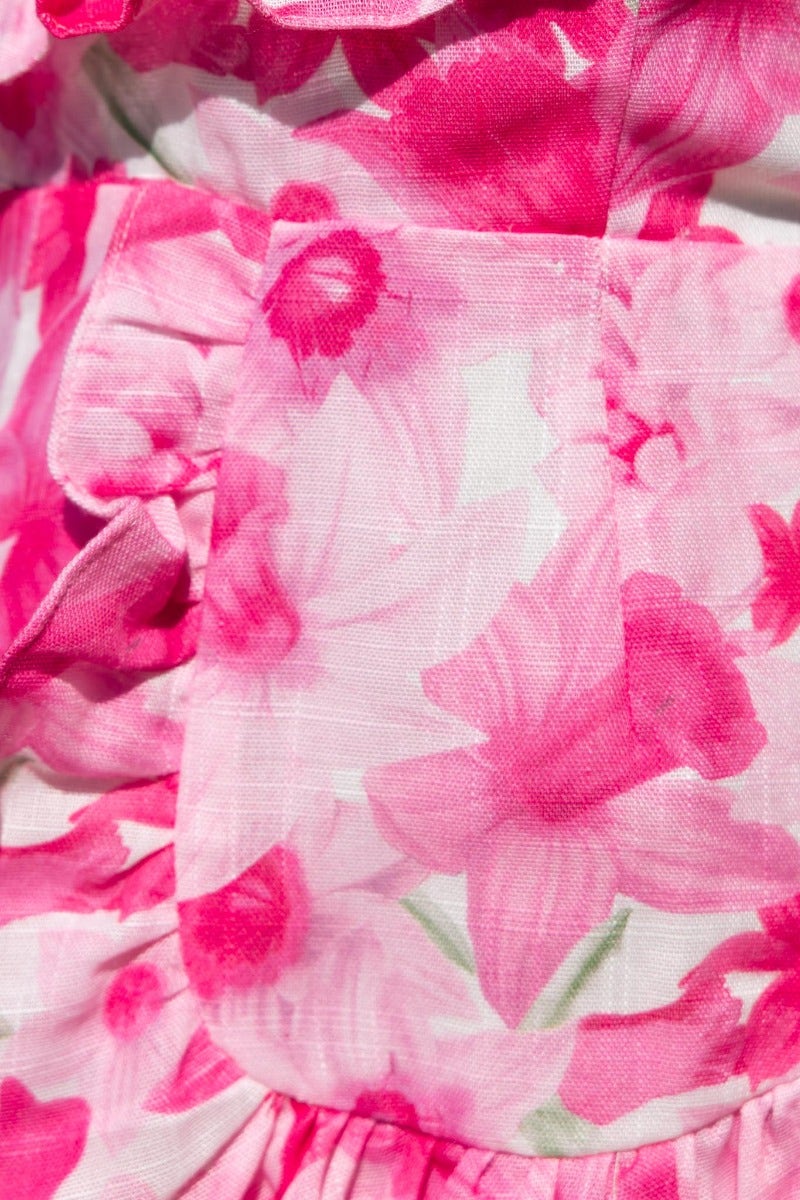 Close-up of floral print fabric featuring pink flowers, showcasing ruffle trim details of the Night Changes Dress.