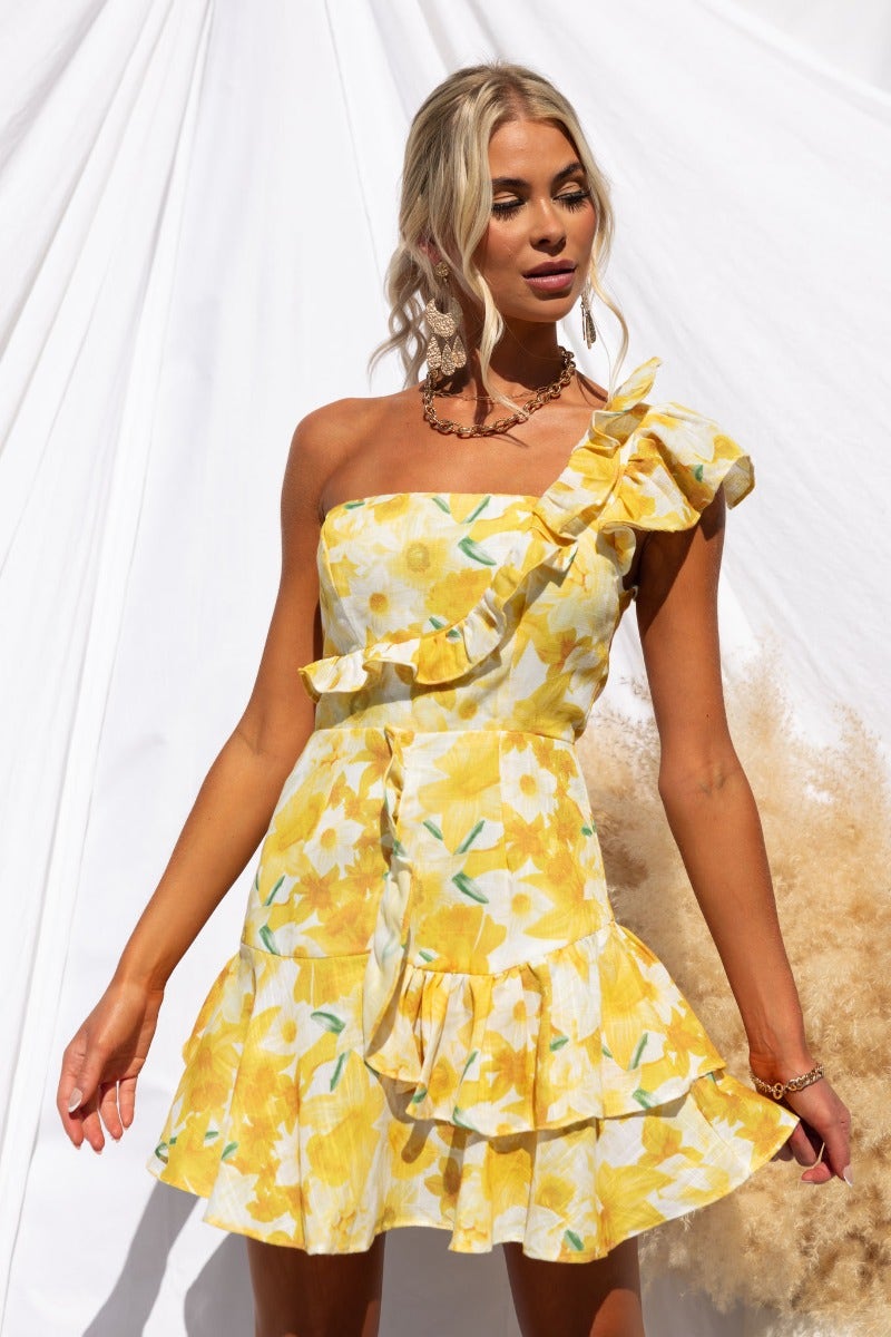 Floral print one-shoulder dress with ruffle trim and layered skirt in yellow.