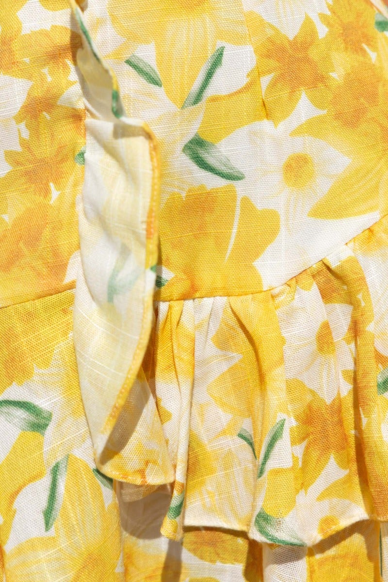 Close-up of floral print fabric featuring yellow daffodils and ruffle trim for Night Changes Dress.