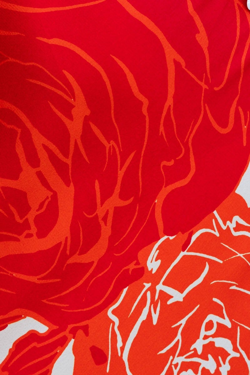 Bright red floral pattern on fabric, ideal for a Shana maxi dress, showcasing vibrant roses in bold colors.