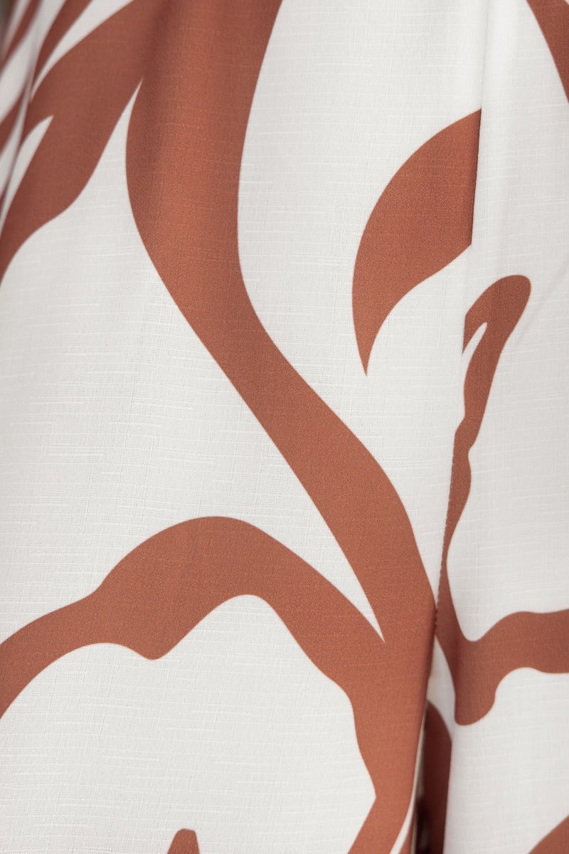 Close-up of floral print fabric in warm tones, showcasing the texture and design of the Girl Almighty Jumpsuit.