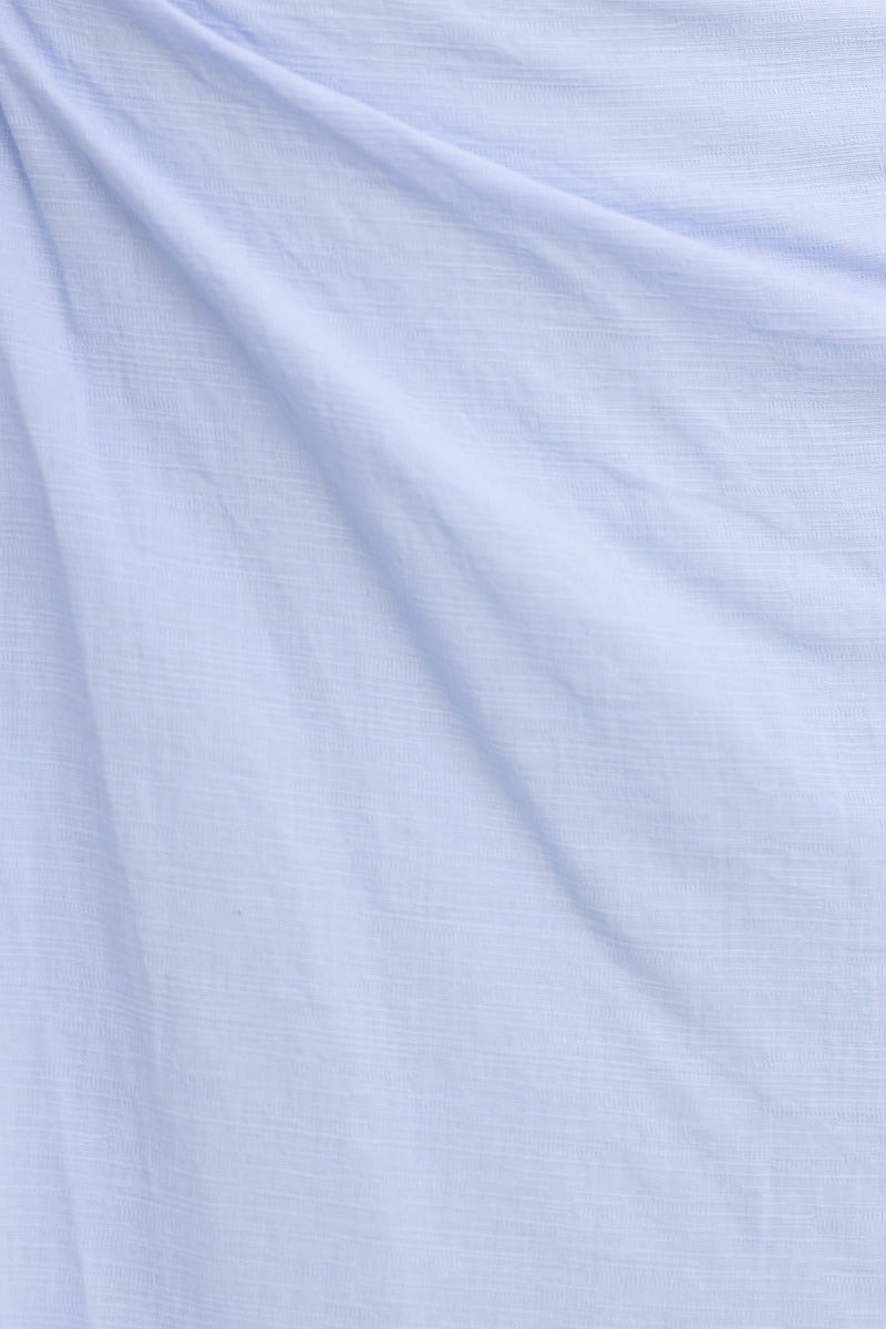 Soft light blue cotton fabric draped elegantly, perfect for a summery maxi dress design.