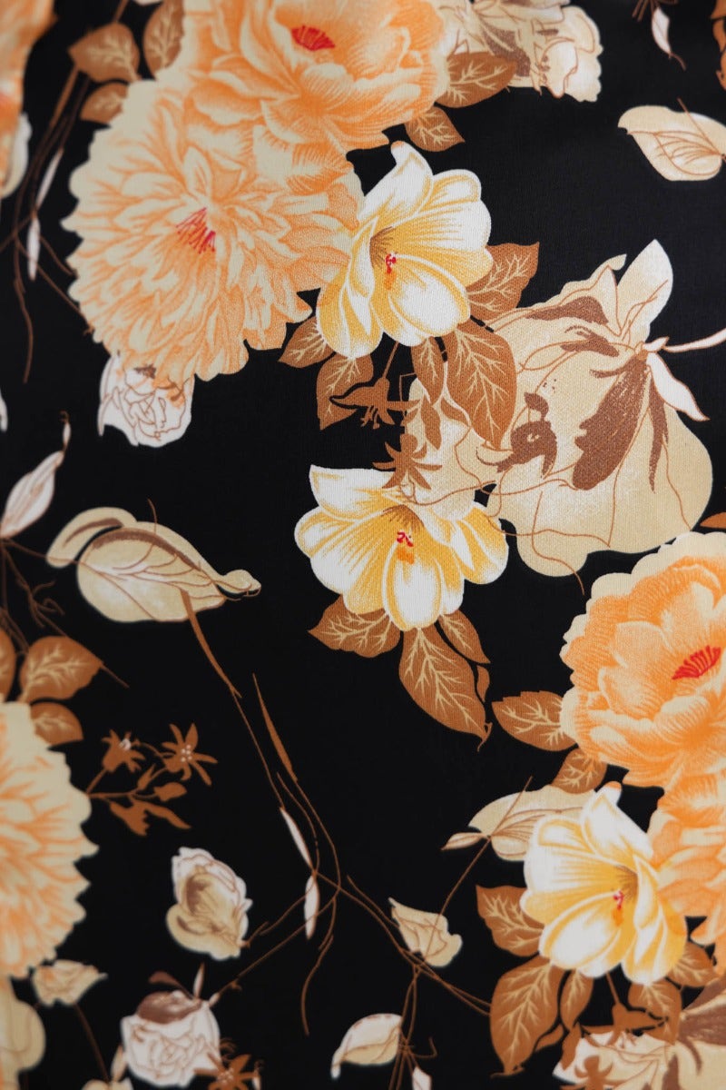 Vibrant orange and yellow floral pattern on black fabric, perfect for a maxi dress or stylish clothing design.