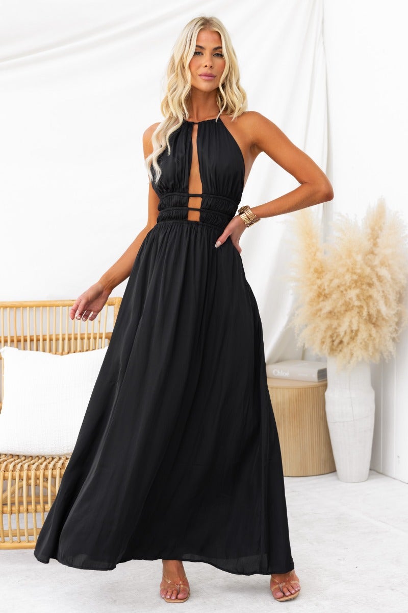 Model wearing Kariah Maxi Dress, a black halter neck gown with cut-outs and elastic waistband.