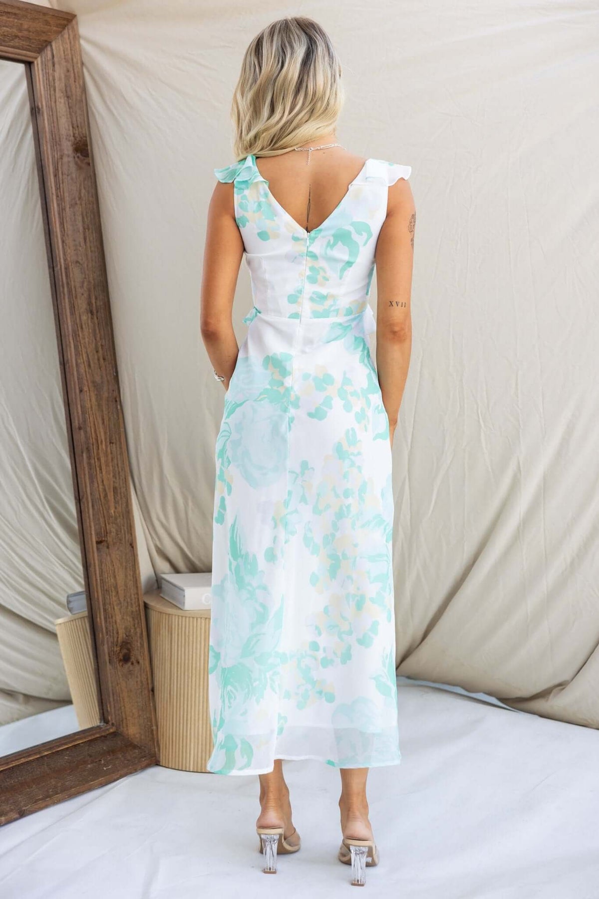Model wearing a Bonnet Maxi Dress featuring a V-neckline and ruffle detail, with a beautiful floral design.