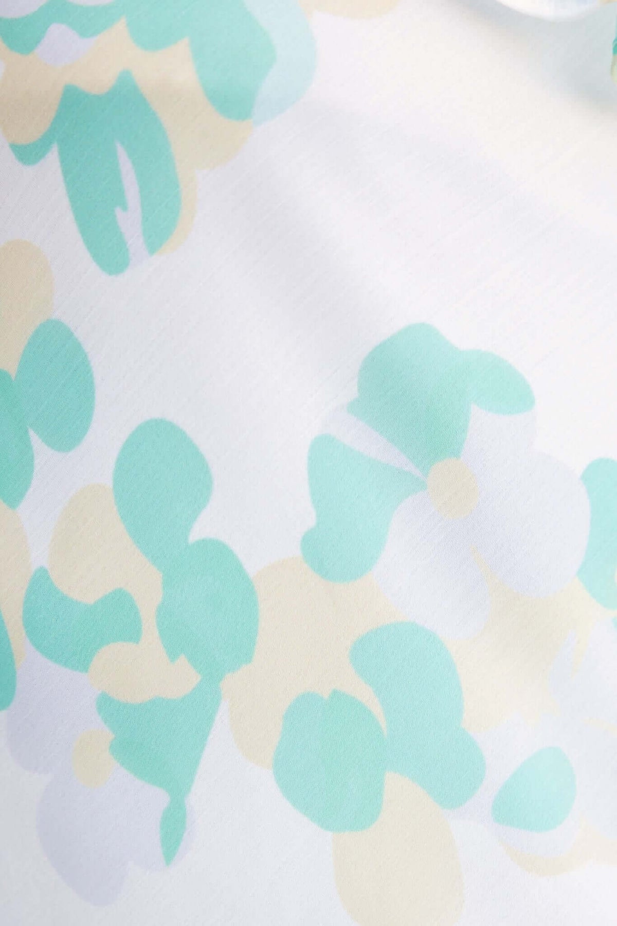 Close-up of chiffon fabric featuring a pastel floral print in mint and cream colors, ideal for a Bonnet Maxi Dress.