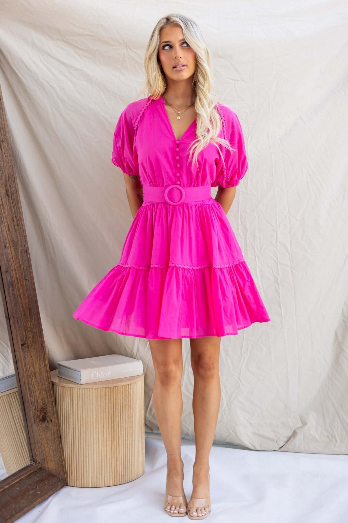 Bright pink Verlaine Dress featuring a V-neckline, button-up bust, and tiered skirt, perfect for summer outings.