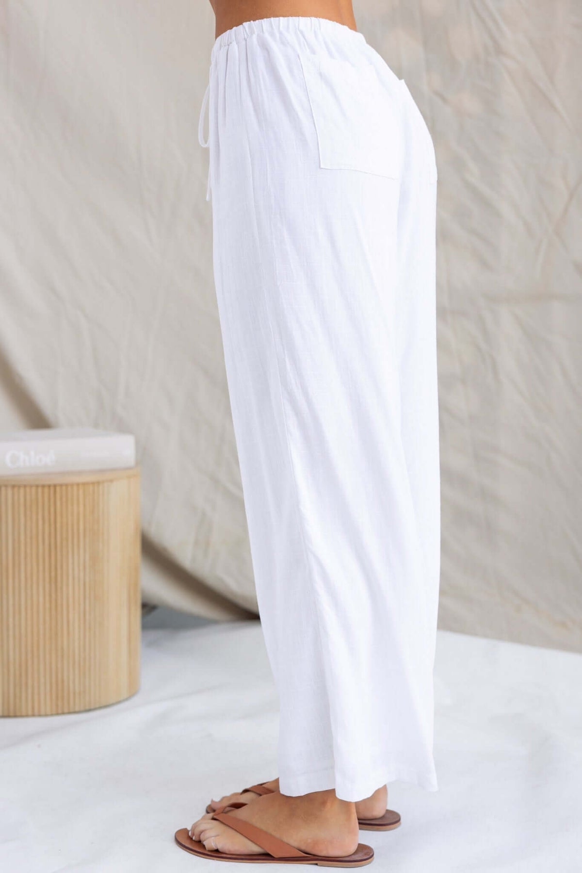 Side view of Irina Pants featuring elastic waistband, pockets, and lightweight fabric in white.