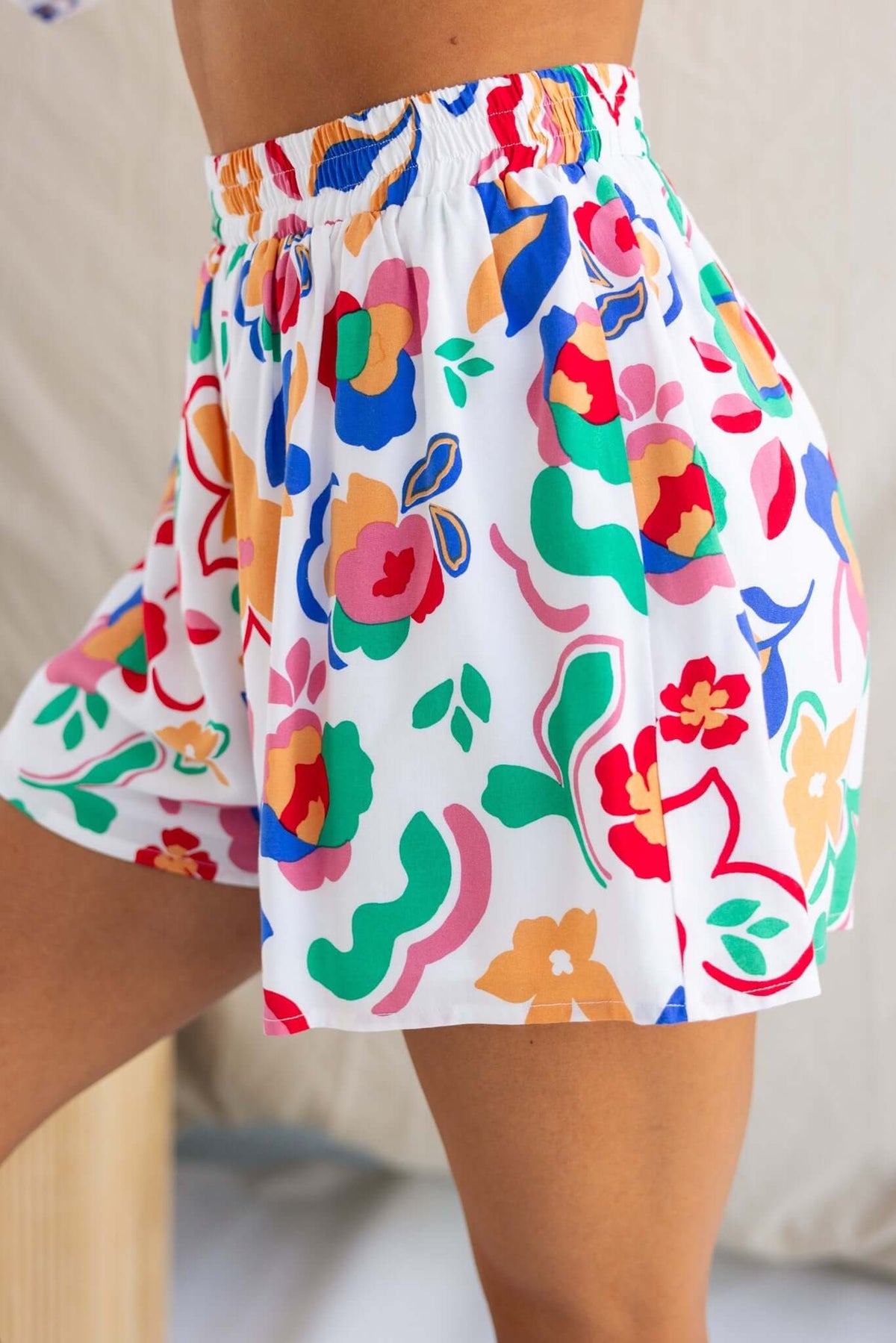Colorful Bonito Shorts with floral pattern, mid-high waist fit, and elastic waistband, perfect for summer wear.