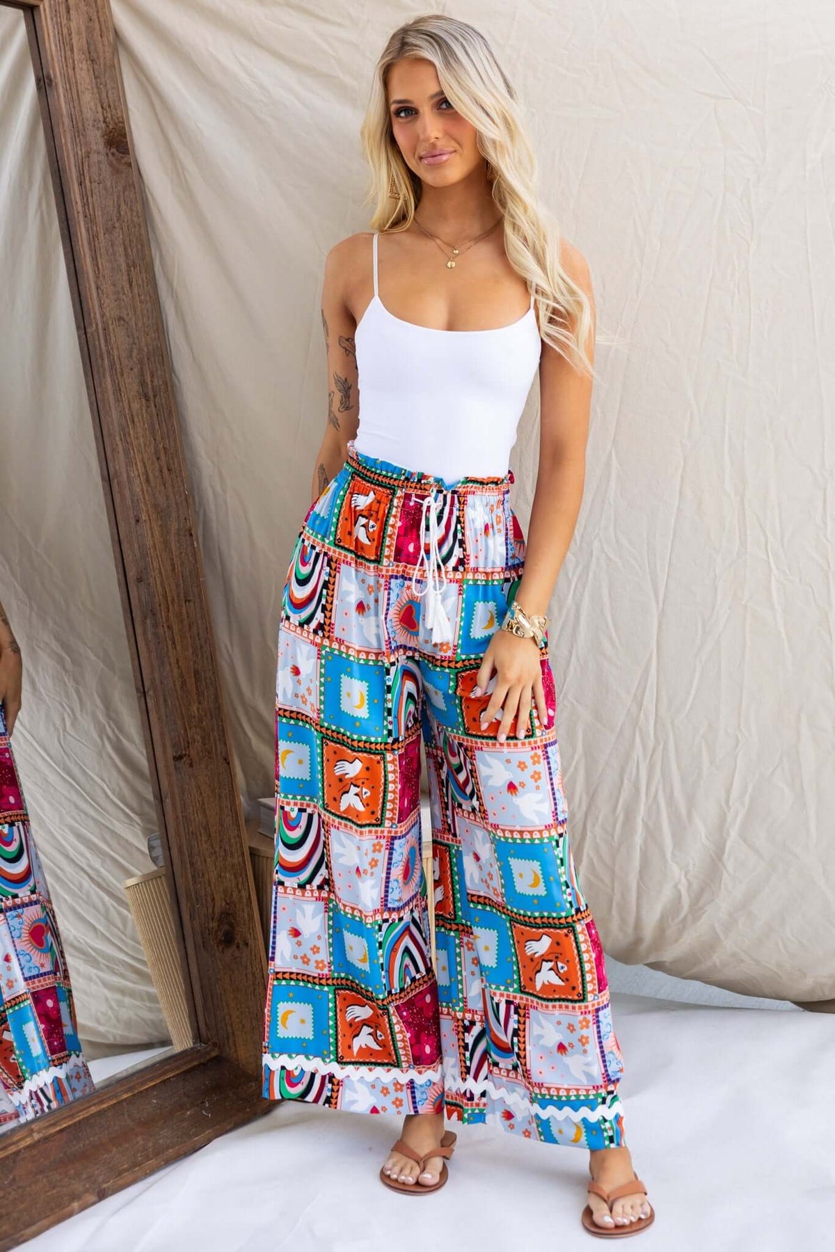 Model wearing Maito Pants with a mid-high waist, colorful patchwork design, featuring an elastic waistband and pockets.