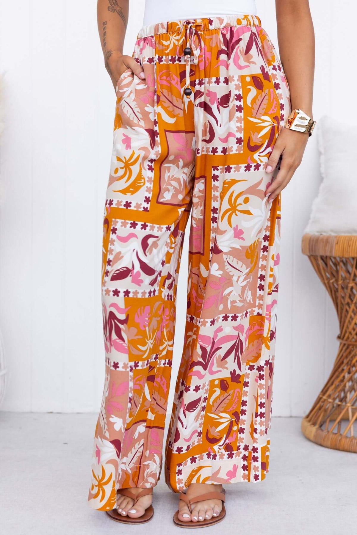 Valora Pants featuring a mid-high waist, elastic drawstring waistband, and vibrant floral print design.