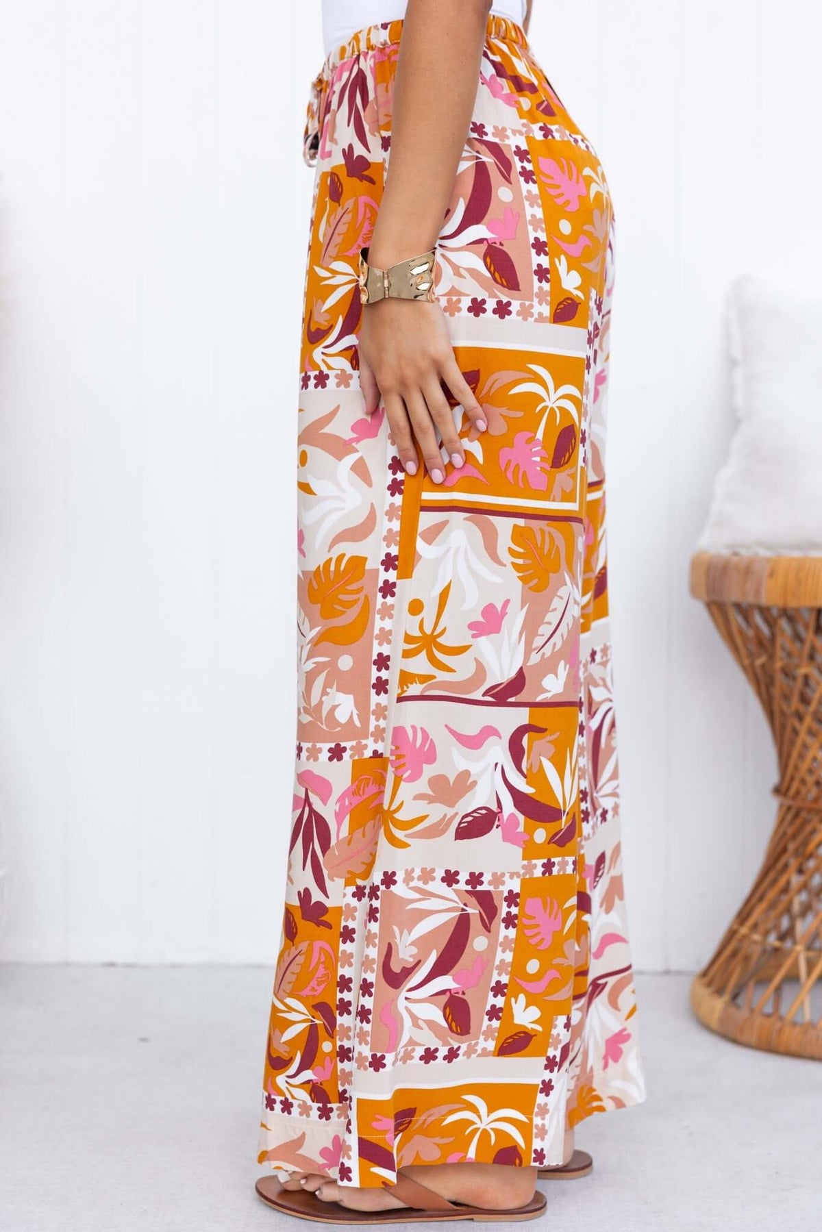 Side view of Valora Pants featuring a vibrant floral pattern, mid-high waist fit, and elastic waistband with drawstring.