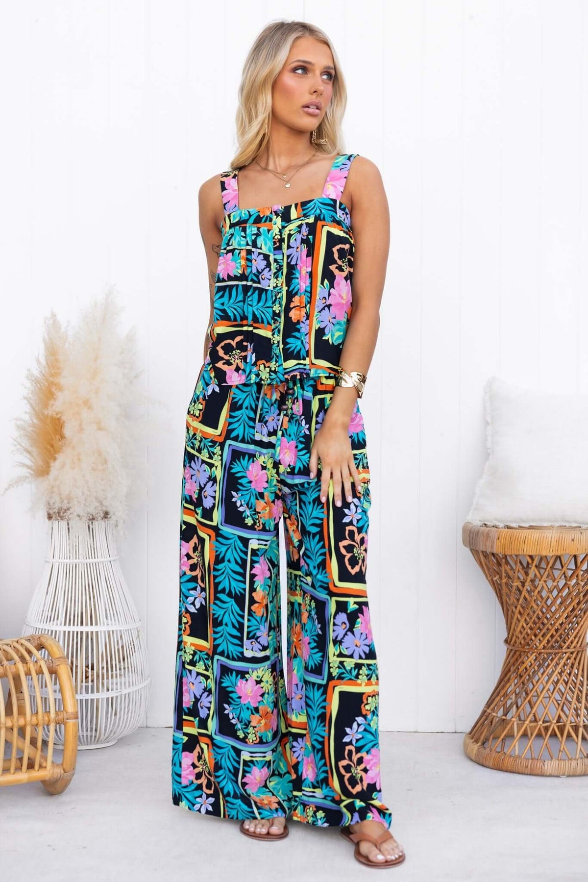 Model wearing Delray Top with adjustable straps, colorful floral print, and button-up front.