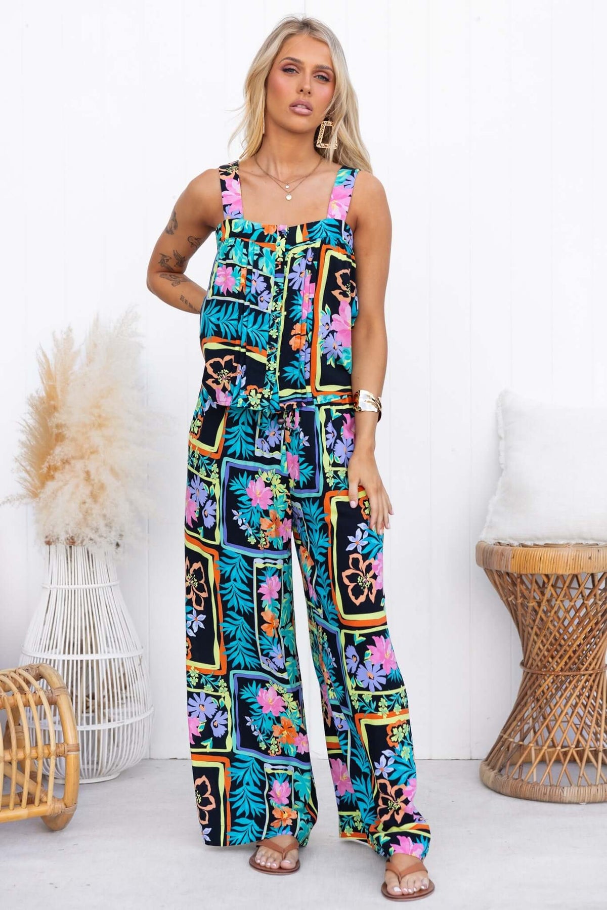 Model wearing vibrant, floral print Delray Pants with wide legs, a mid-high waist, and an elastic drawstring waistband.