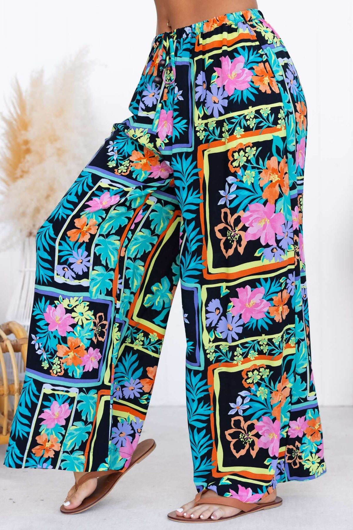 Colorful floral print Delray pants with mid-high waist and elastic waistband, perfect for casual wear.