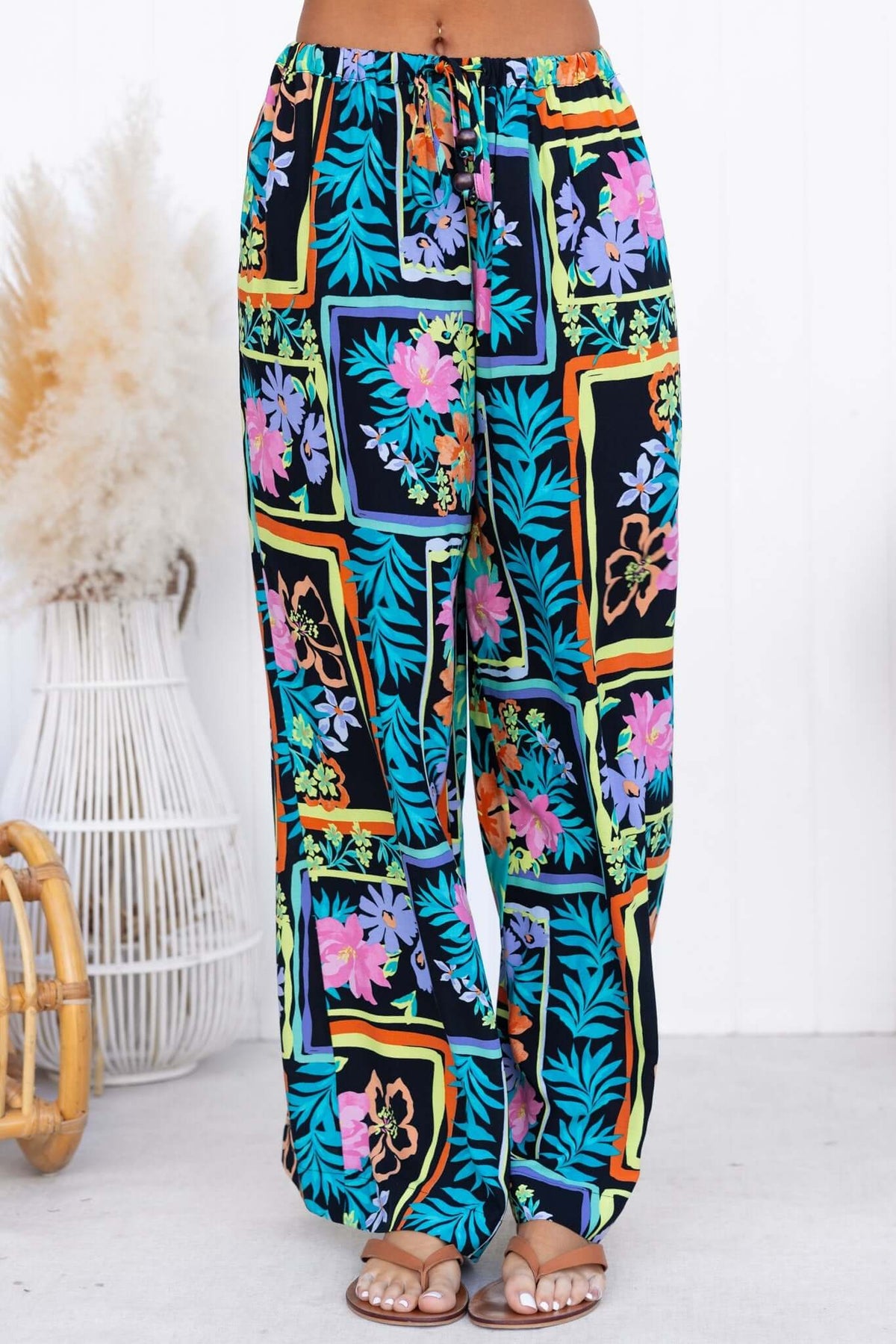 Delray Pants featuring vibrant floral print, mid-high waist fit, elastic waistband, and casual style.