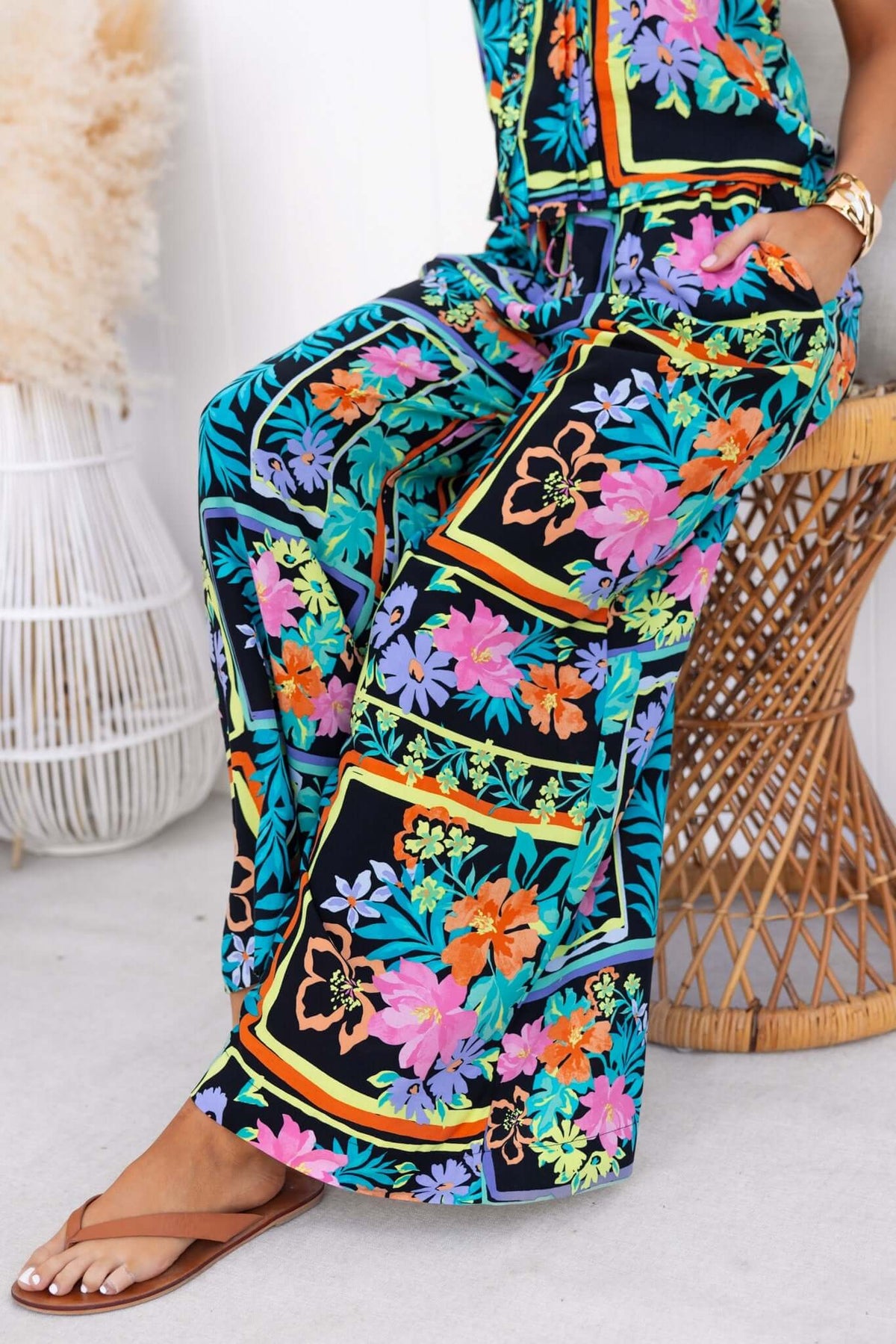 Delray Pants featuring a colorful floral design, mid-high waist, elastic waistband, and side pockets, perfect for casual wear.