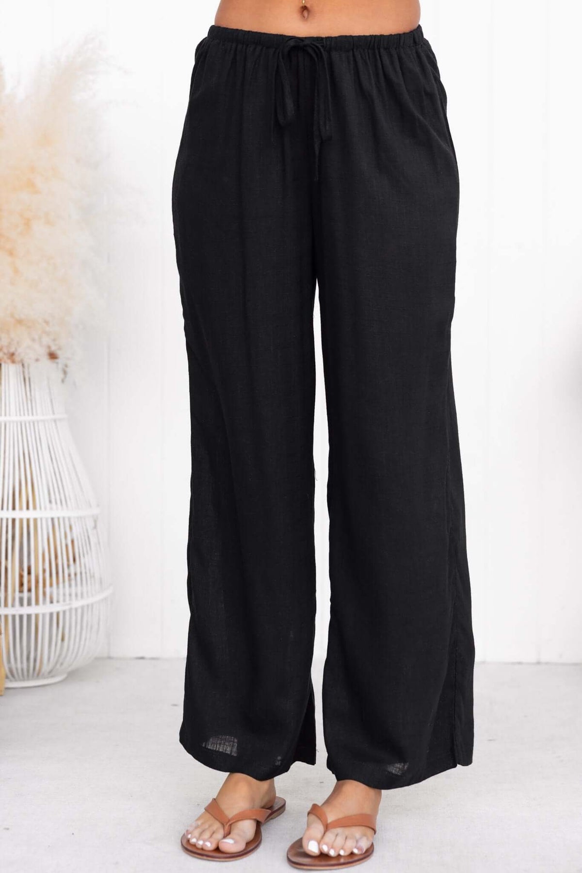 Black Irina Pants with elastic waistband and drawstring, featuring back pockets and a relaxed fit.