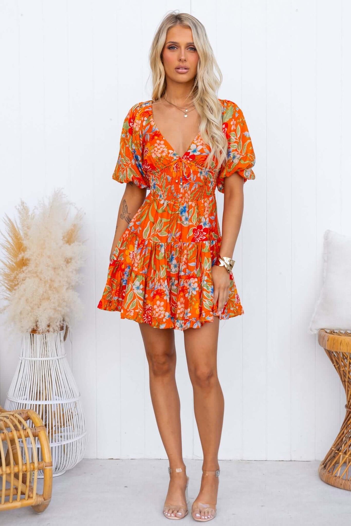 Airi Dress featuring a vibrant floral pattern, V-neckline, elastic sleeves, and a flared skirt, perfect for summer outings.