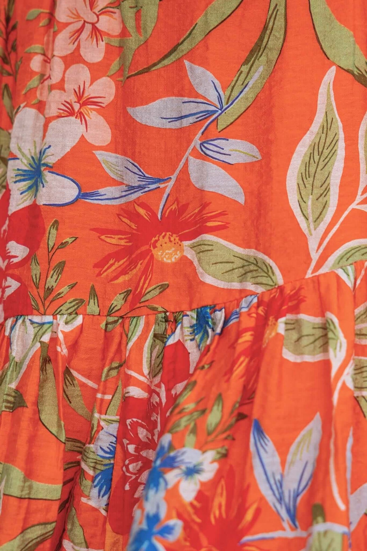 Airi Dress close-up featuring vibrant floral patterns in orange, blue, and green, showcasing its lightweight fabric.