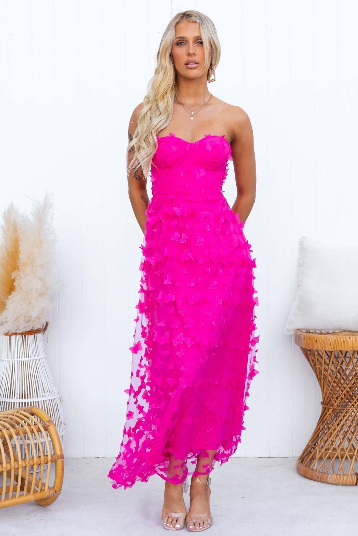 Model wearing a vibrant pink strapless Violette Maxi Dress with tulle material, showcasing a floral design.