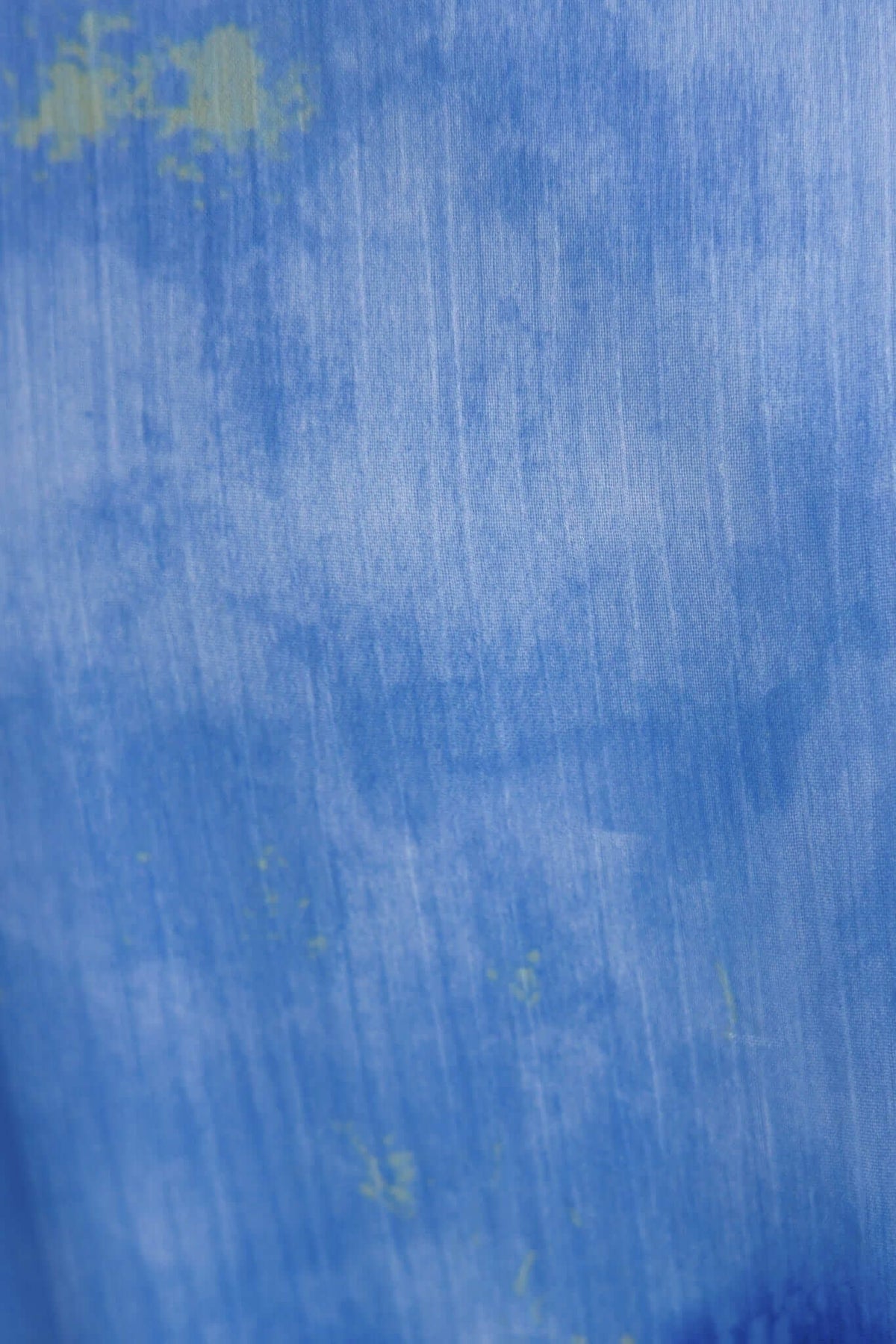 Close-up of textured blue fabric with subtle green accents, perfect for a stylish midi dress.