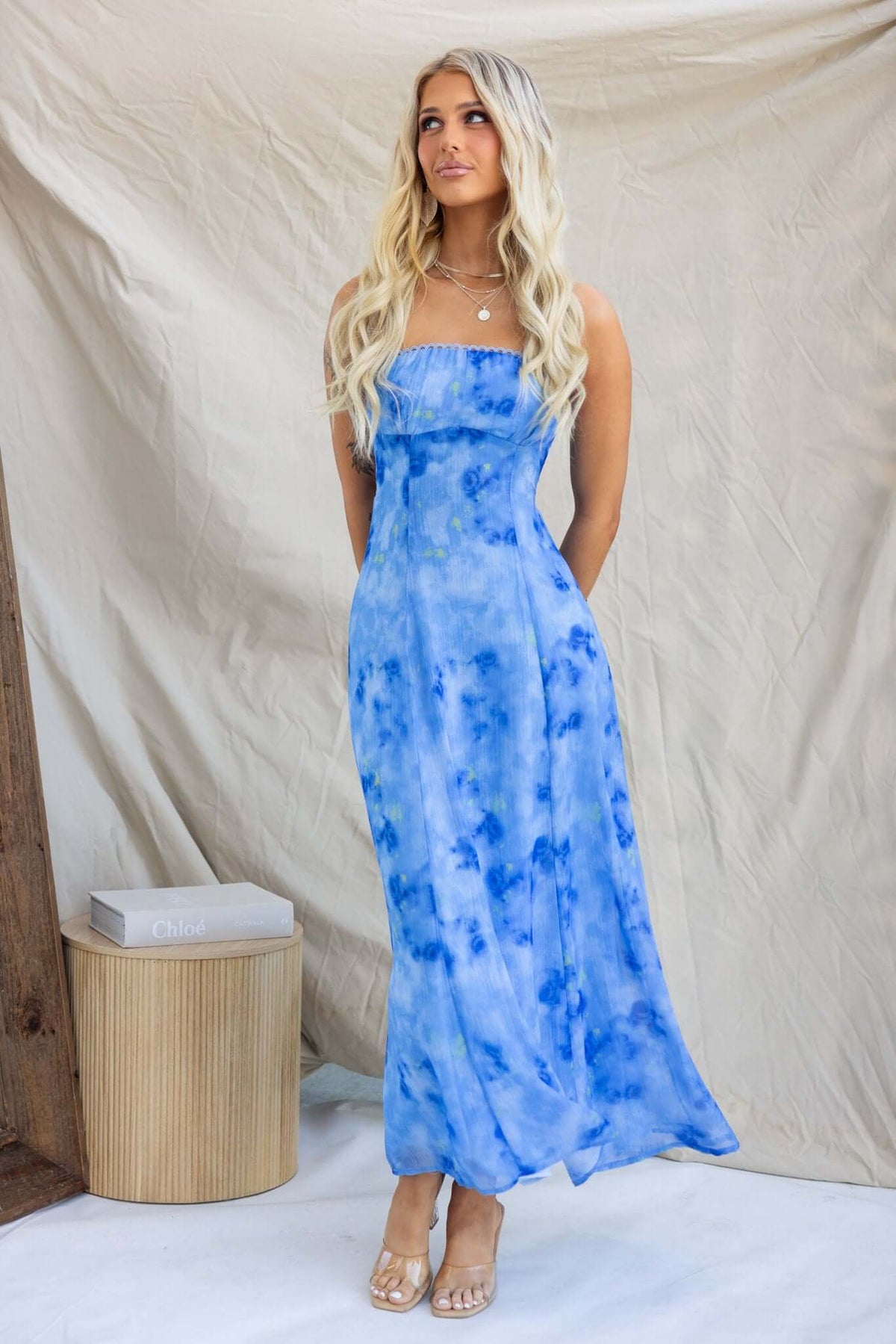 Model wearing a strapless blue tie-dye midi dress with an elastic back and invisible zip, styled for summer.