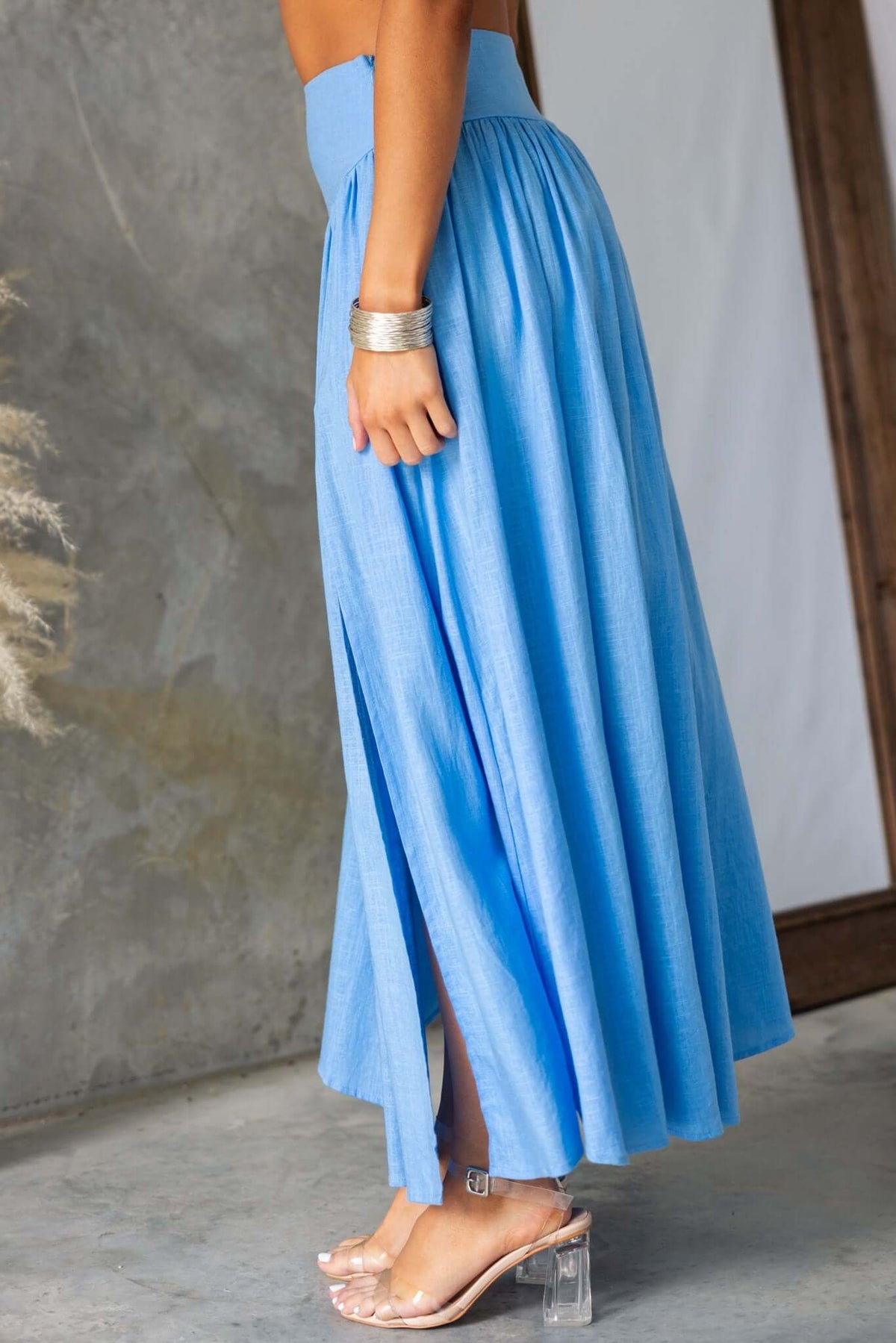Side view of the Gardiner Maxi Skirt in light blue with a mid-high waist and front split, perfect for casual outings.