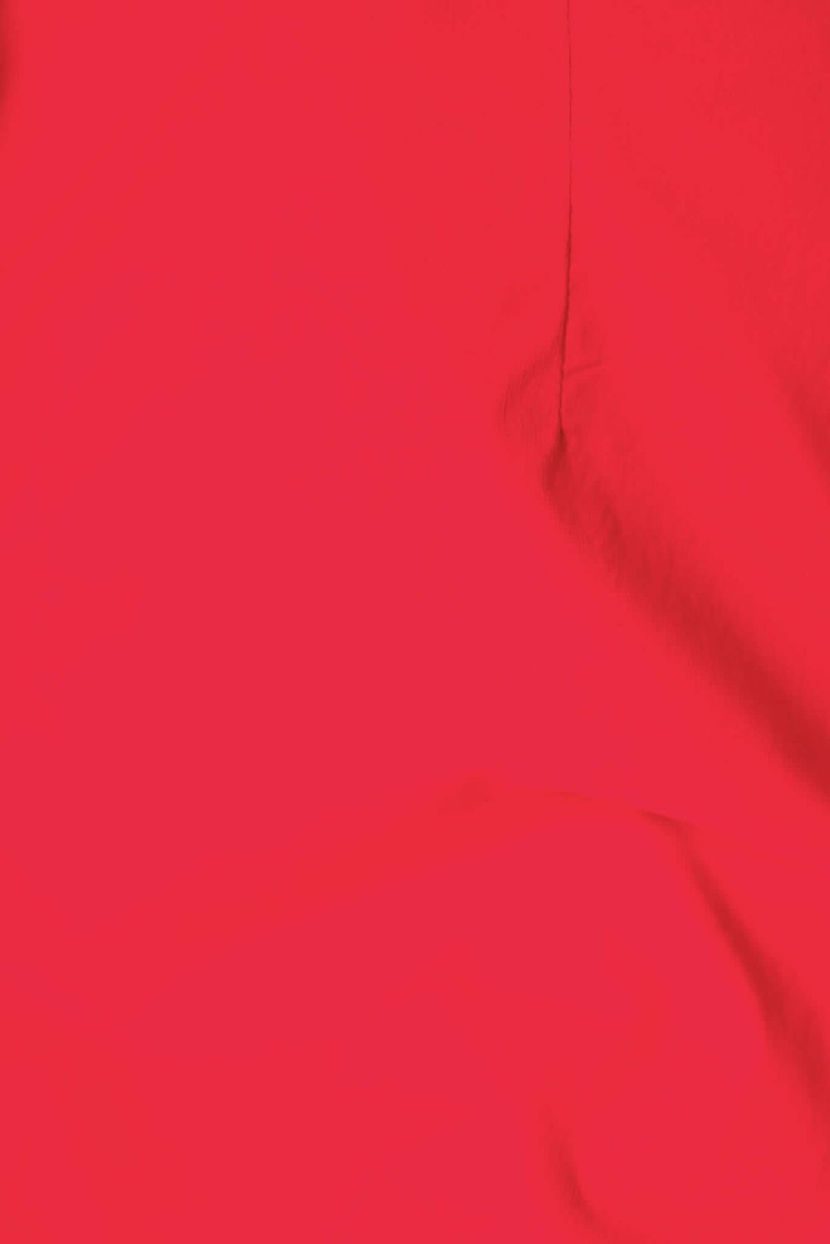 Close-up of bright red Idaho Dress fabric showcasing smooth texture and vibrant color.