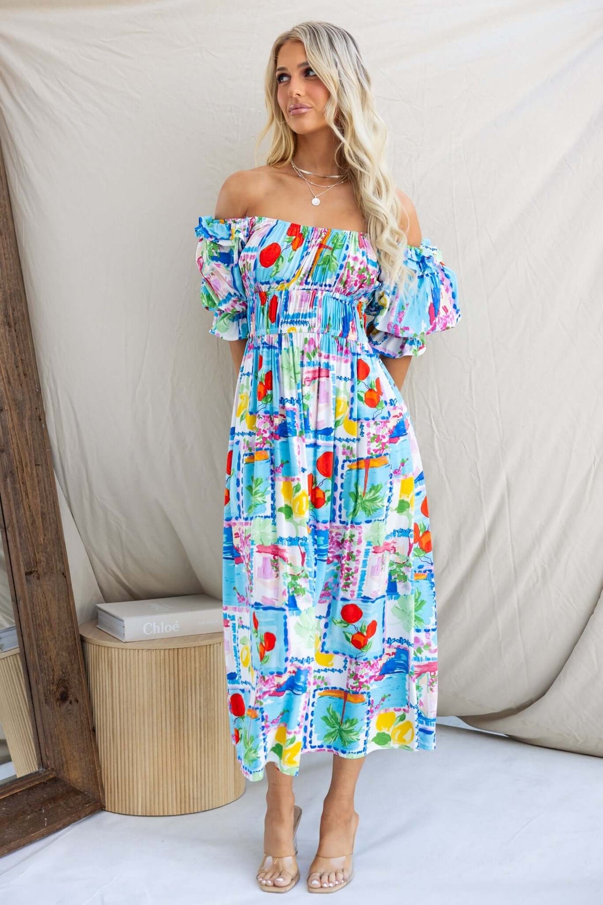 Model wearing a colorful Dewberry Maxi Dress with off-shoulder neckline and pockets against a neutral backdrop.