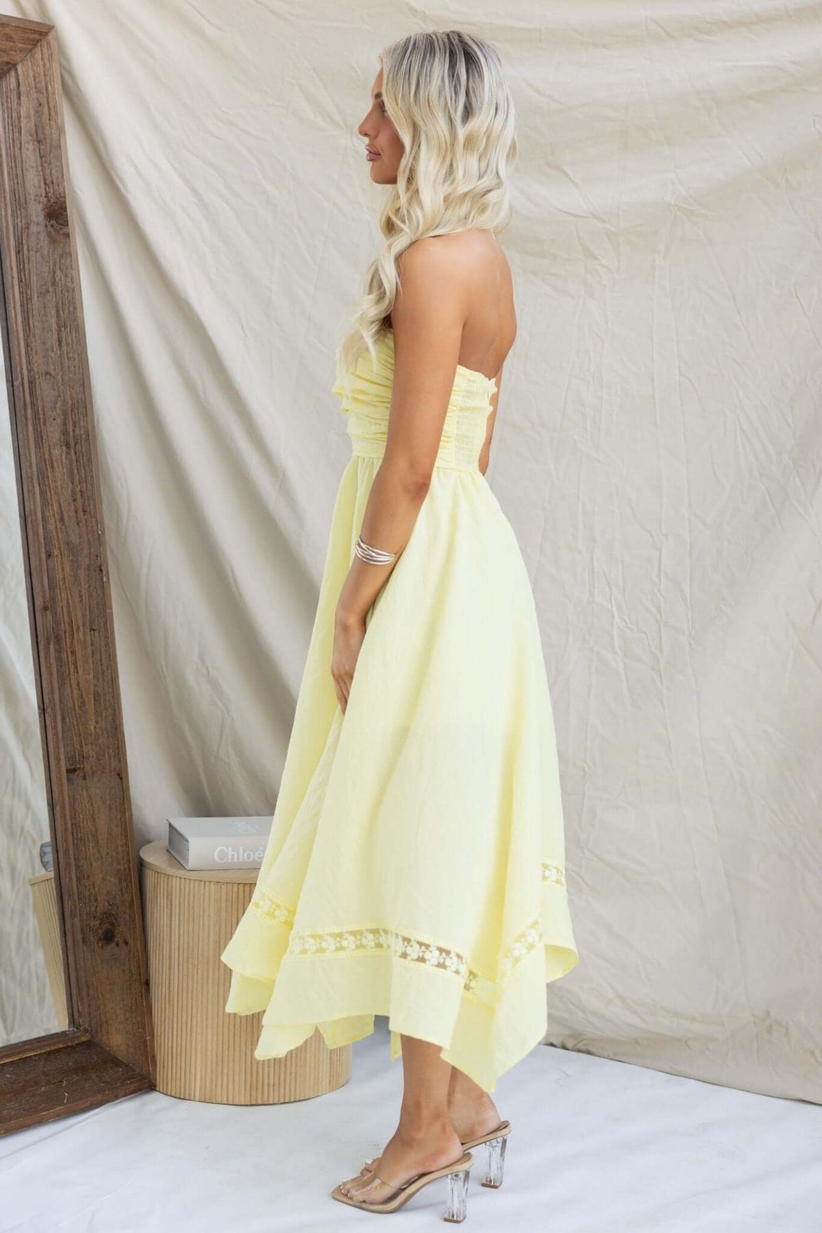Strapless Civita Maxi Dress in yellow, featuring a handkerchief hem and anti-slip bust design, styled by a model.