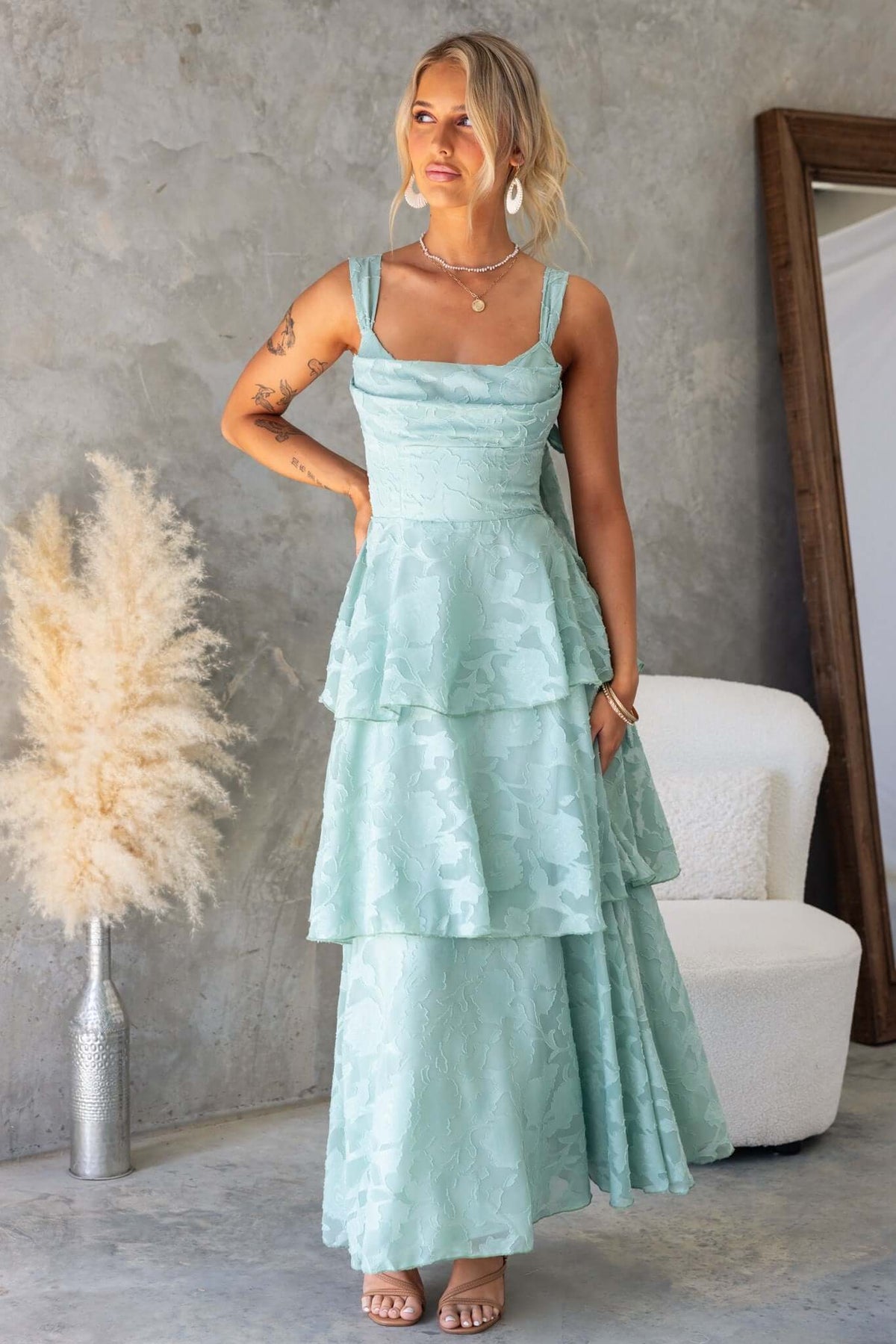 Rivoli Maxi Dress in mint green with ruffle skirt, cowl neckline, and tie straps, displayed in a stylish setting.