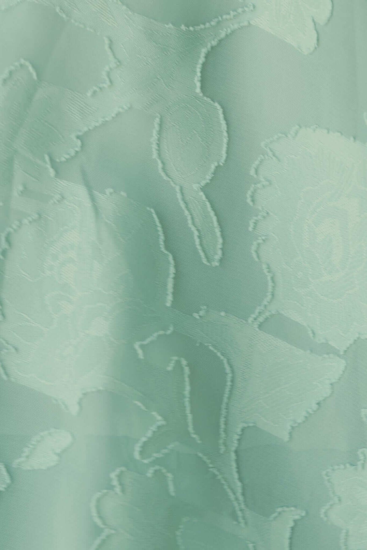 Close-up of textured mint green fabric with floral design, ideal for a stylish maxi dress.