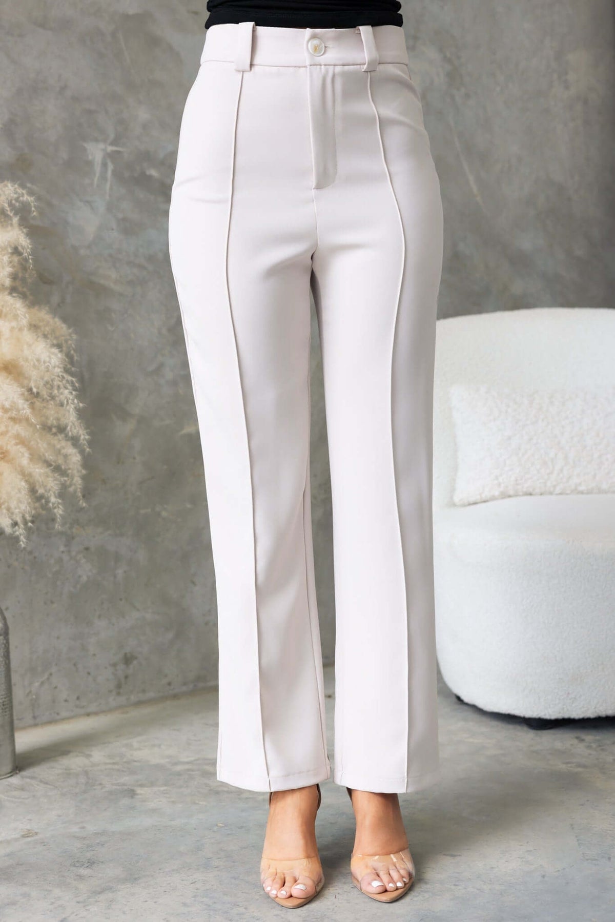 Columbus Pants in light beige with a mid-high waist fit, non-lined design, shown on model in a stylish setting.