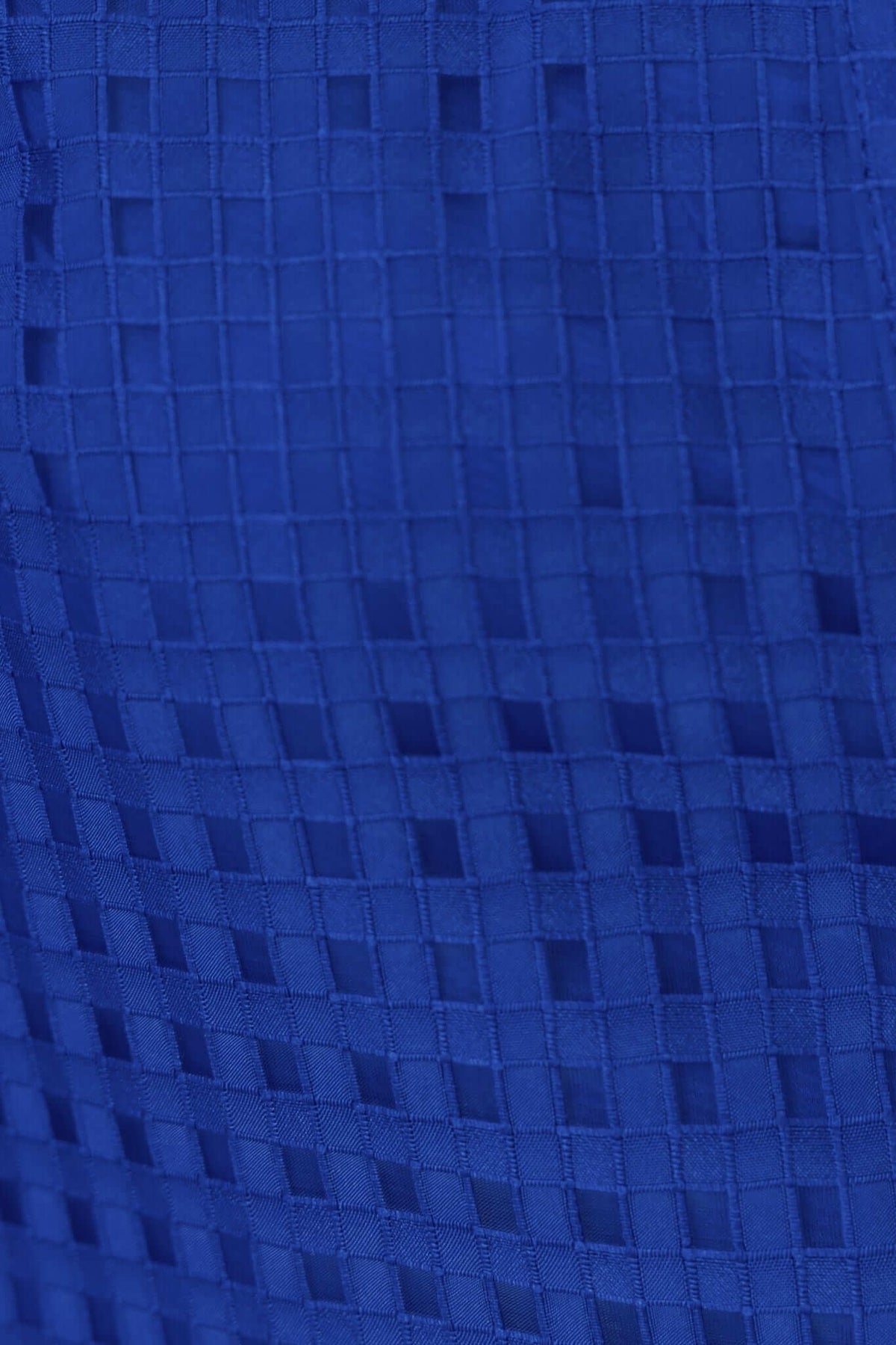 Close-up of textured blue fabric with a grid pattern, showcasing the unique design of the Ursa Shirt.