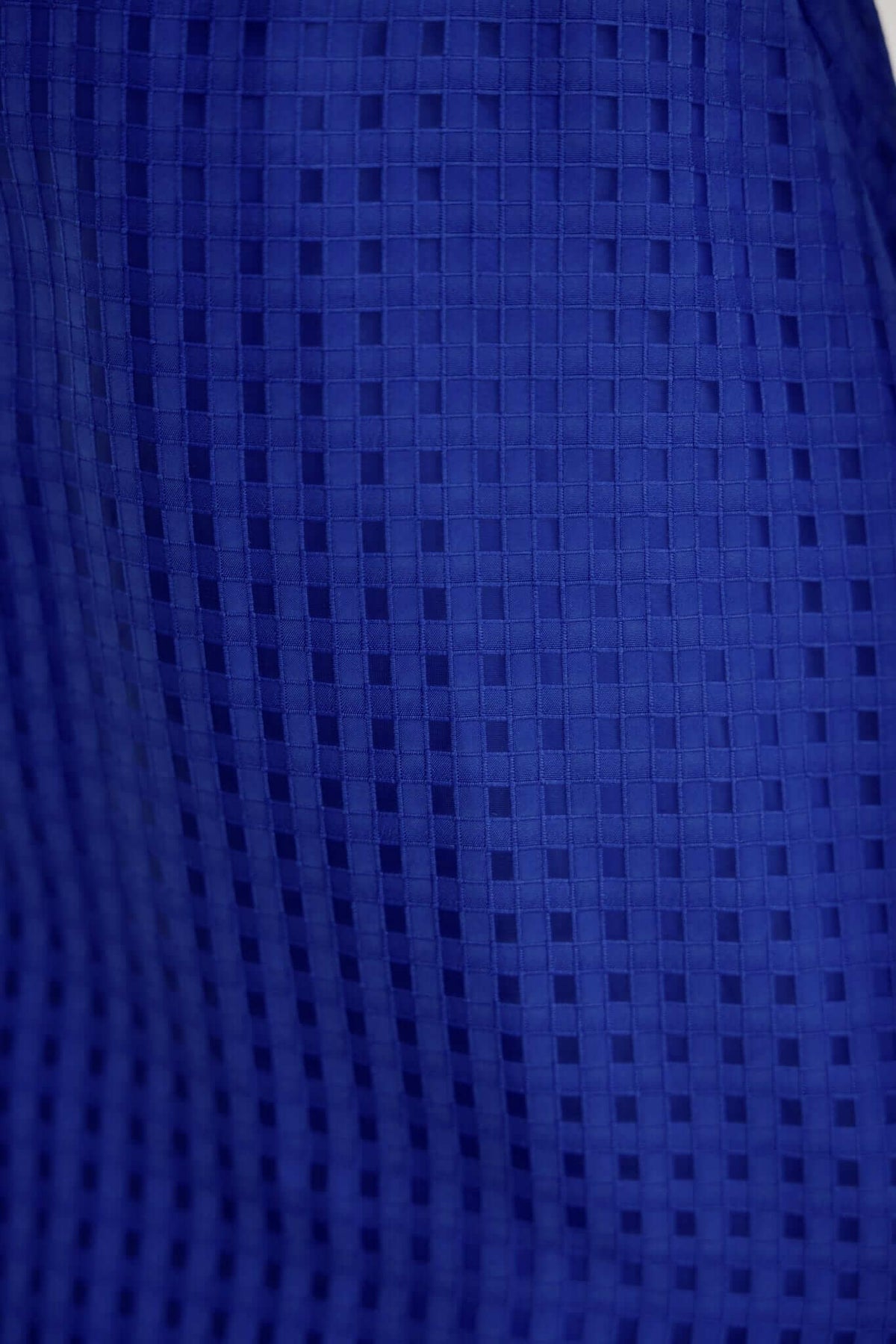 Close-up of textured blue fabric with a grid pattern, ideal for the Nosita Midi Dress.